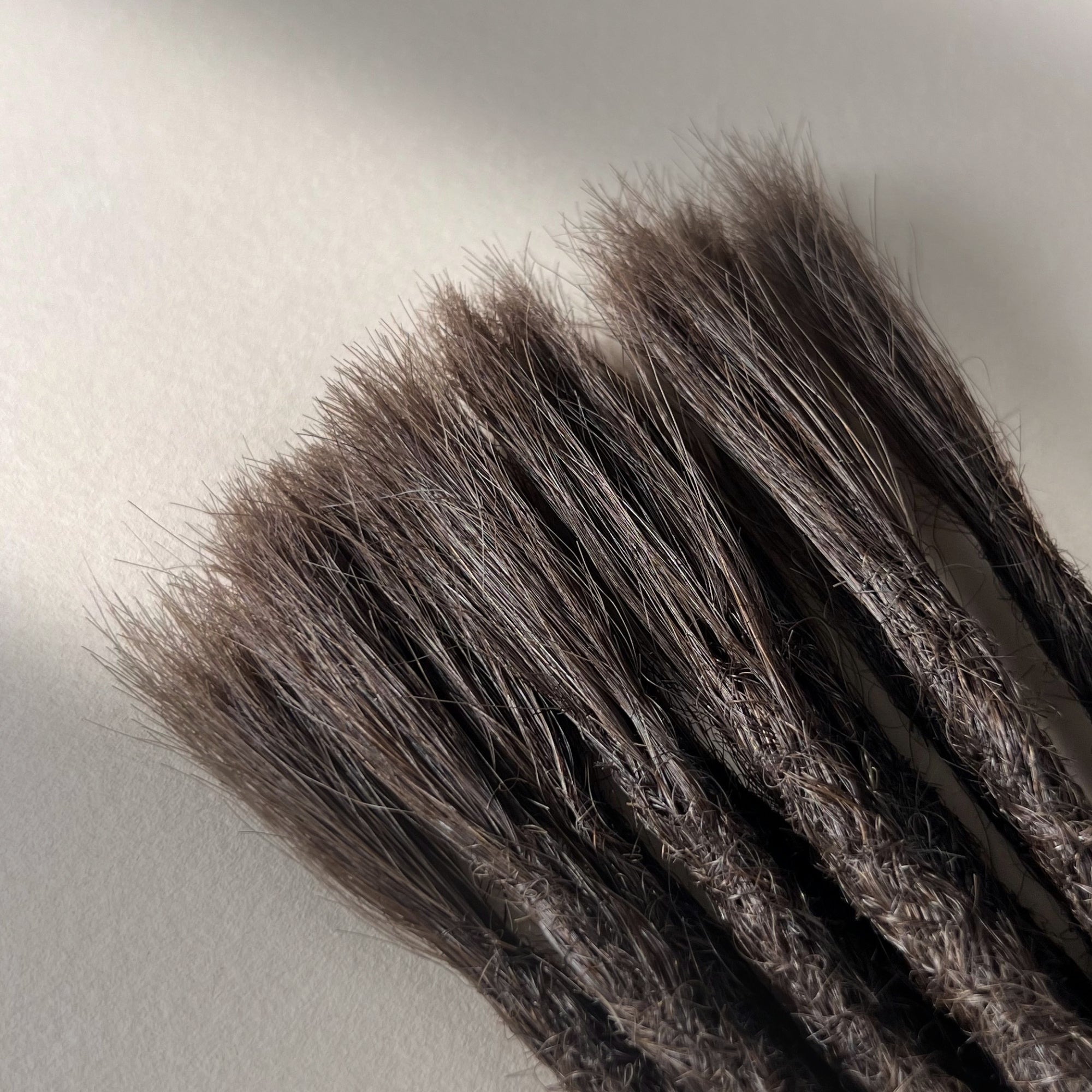 Connection point of permanent straight loc extensions with open ends in Warm Espresso Brown.