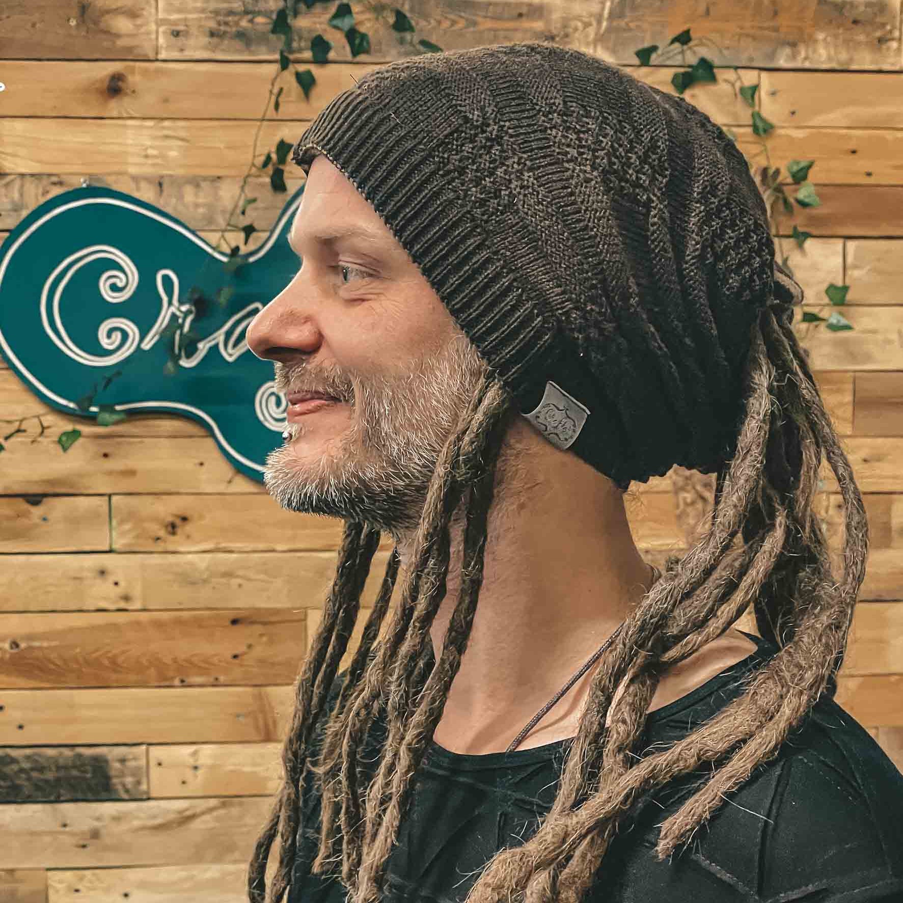 Person wearing a brown CrafterElena Squares beanie with locs