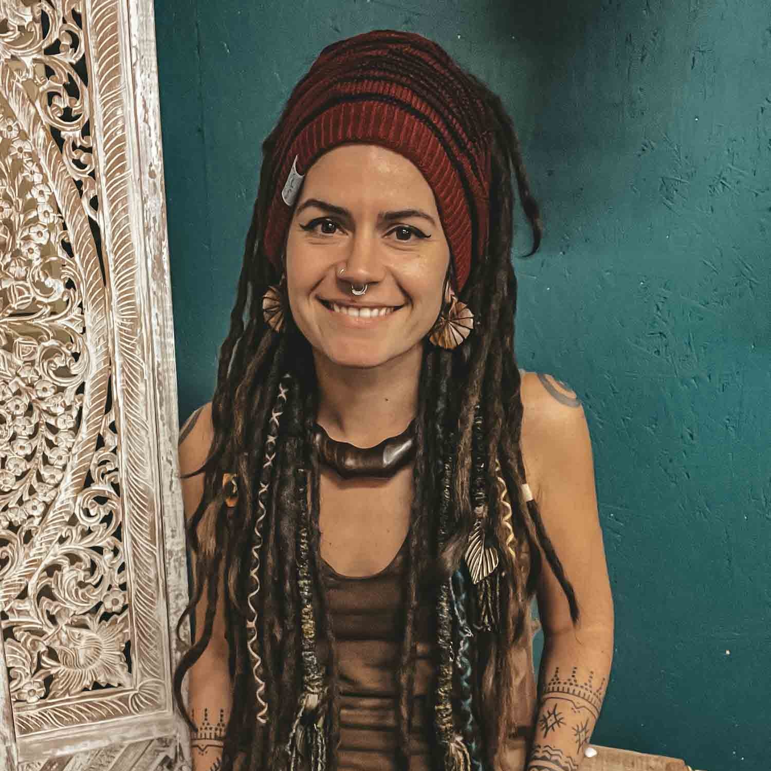 Person wearing a red CrafterElena Striped beanie with locs