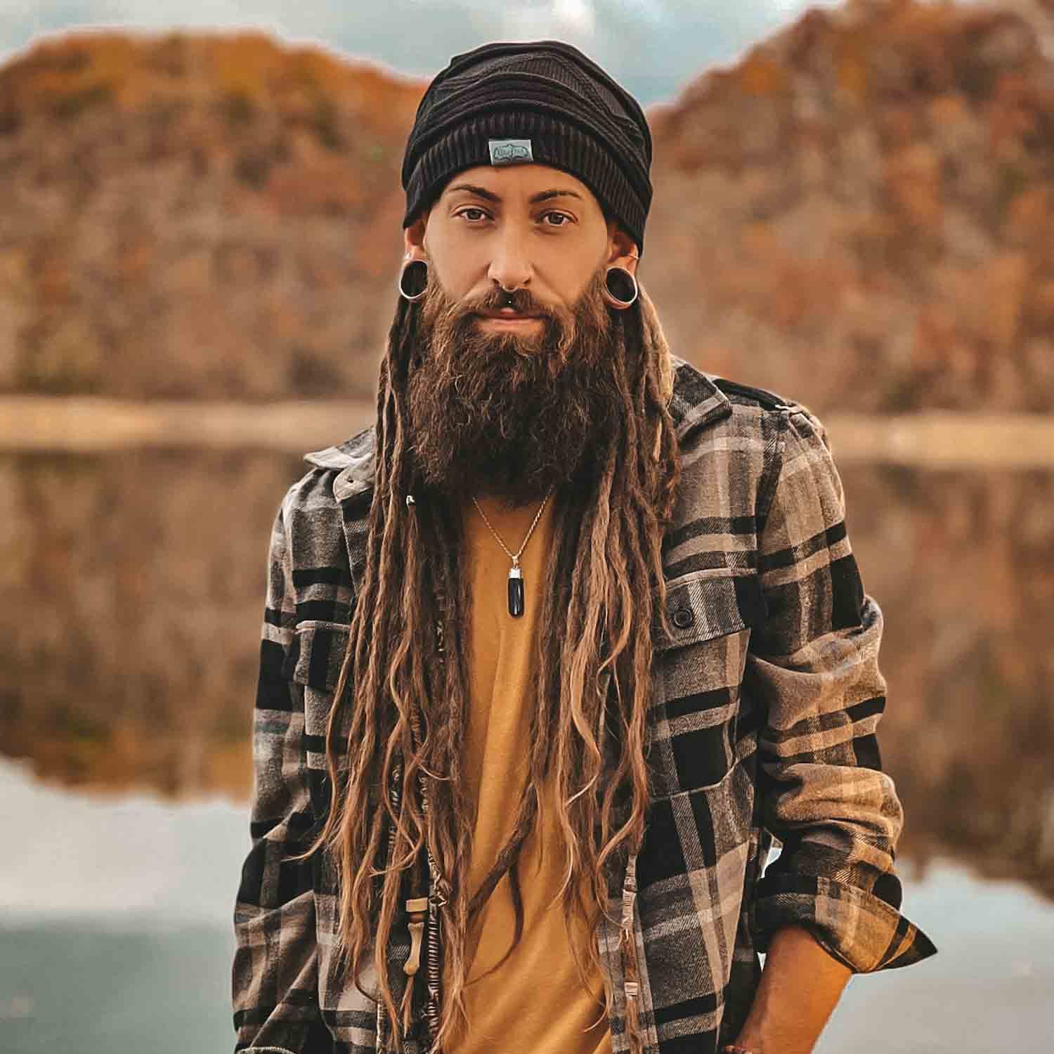 Person wearing a black CrafterElena Triangle beanie with long dreadlocks