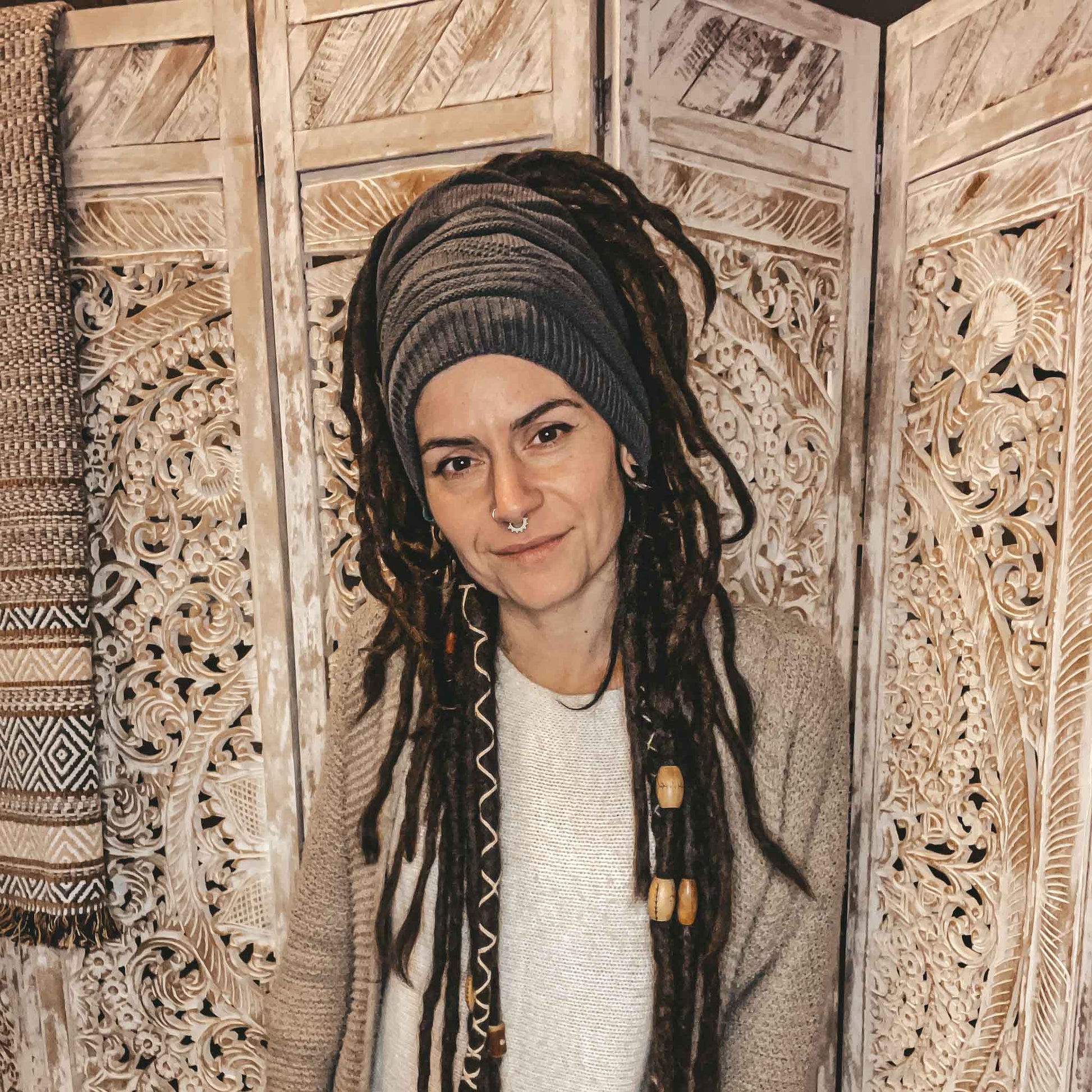 Person wearing a dark grey CrafterElena Triangle beanie with dreadlocks
