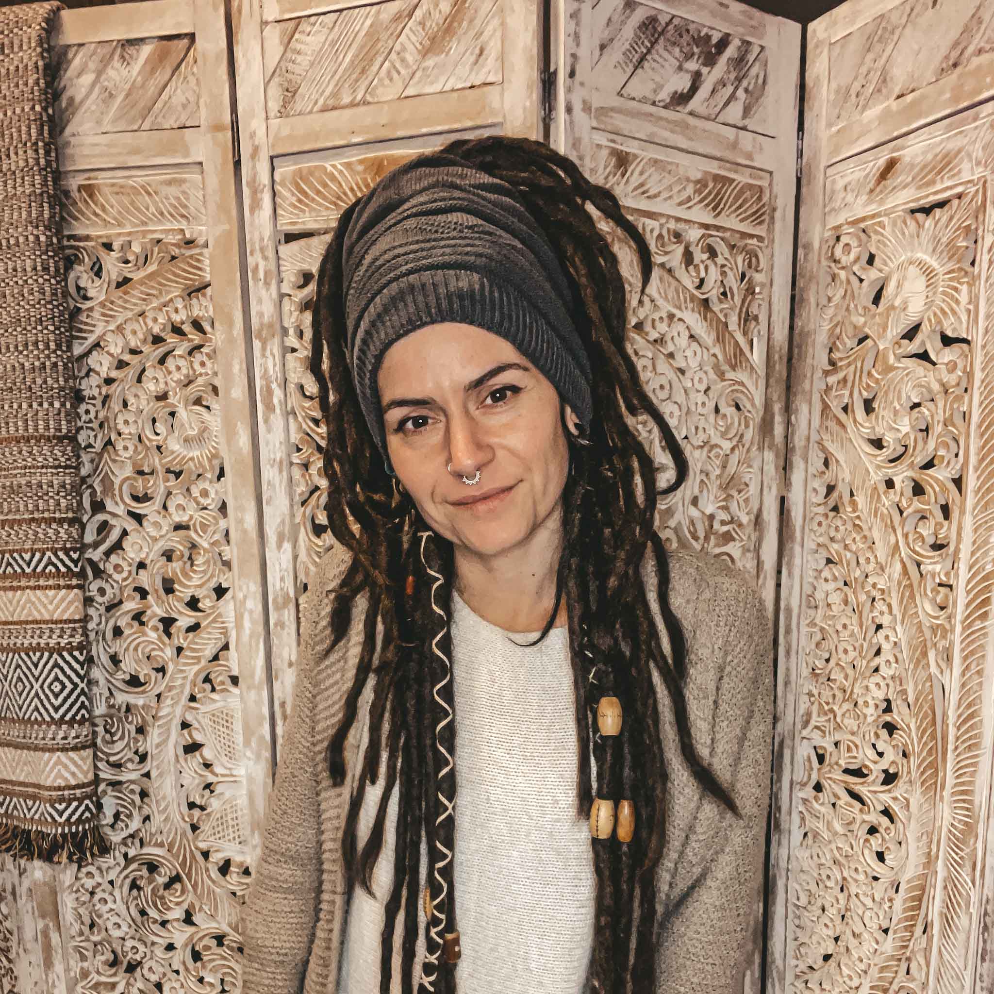 Person wearing a dark grey CrafterElena Triangle beanie with dreadlocks