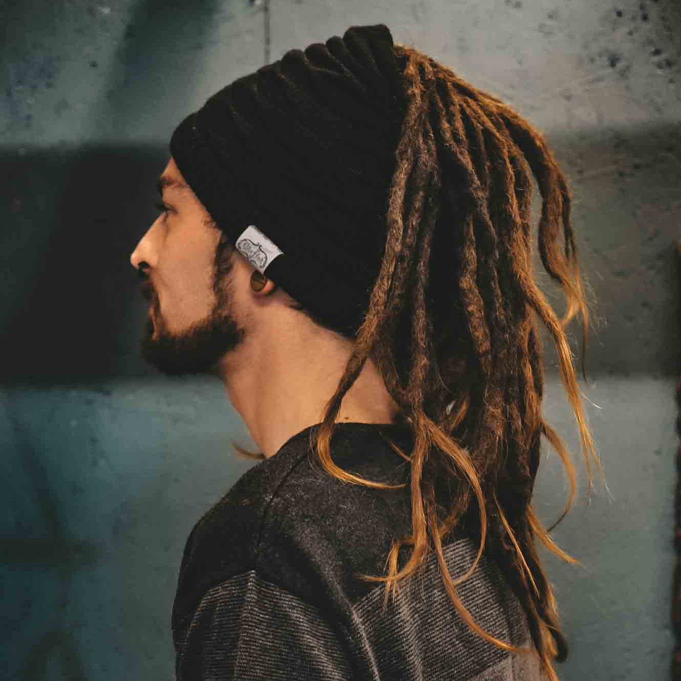 Person wearing a black CrafterElena Wavy beanie with long locs