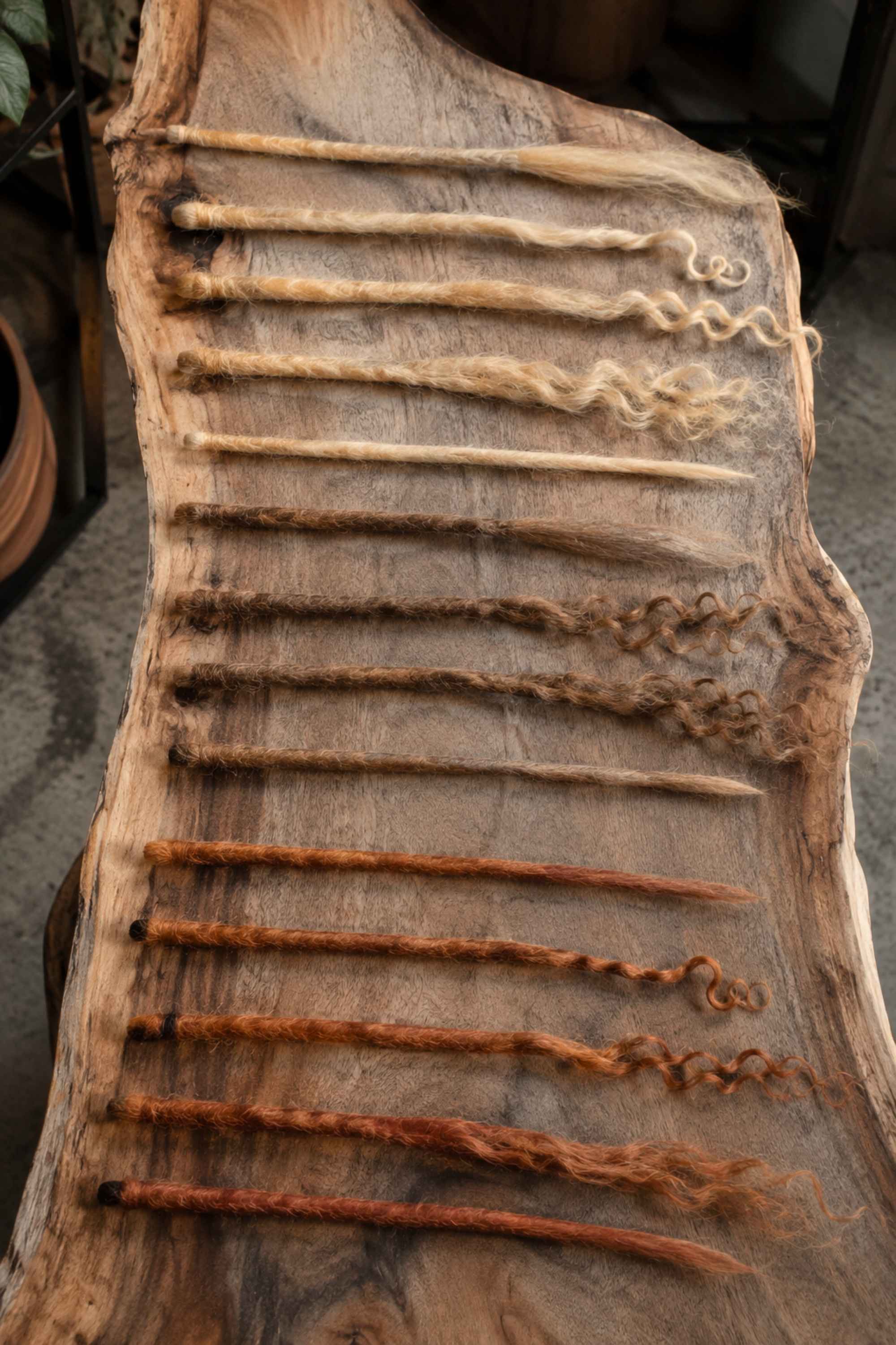 Comparison of handmade loc tip types by Dreadradar, featuring Straight, Wavy, Curly, and Coily tips in different natural shades displayed on a wooden surface.