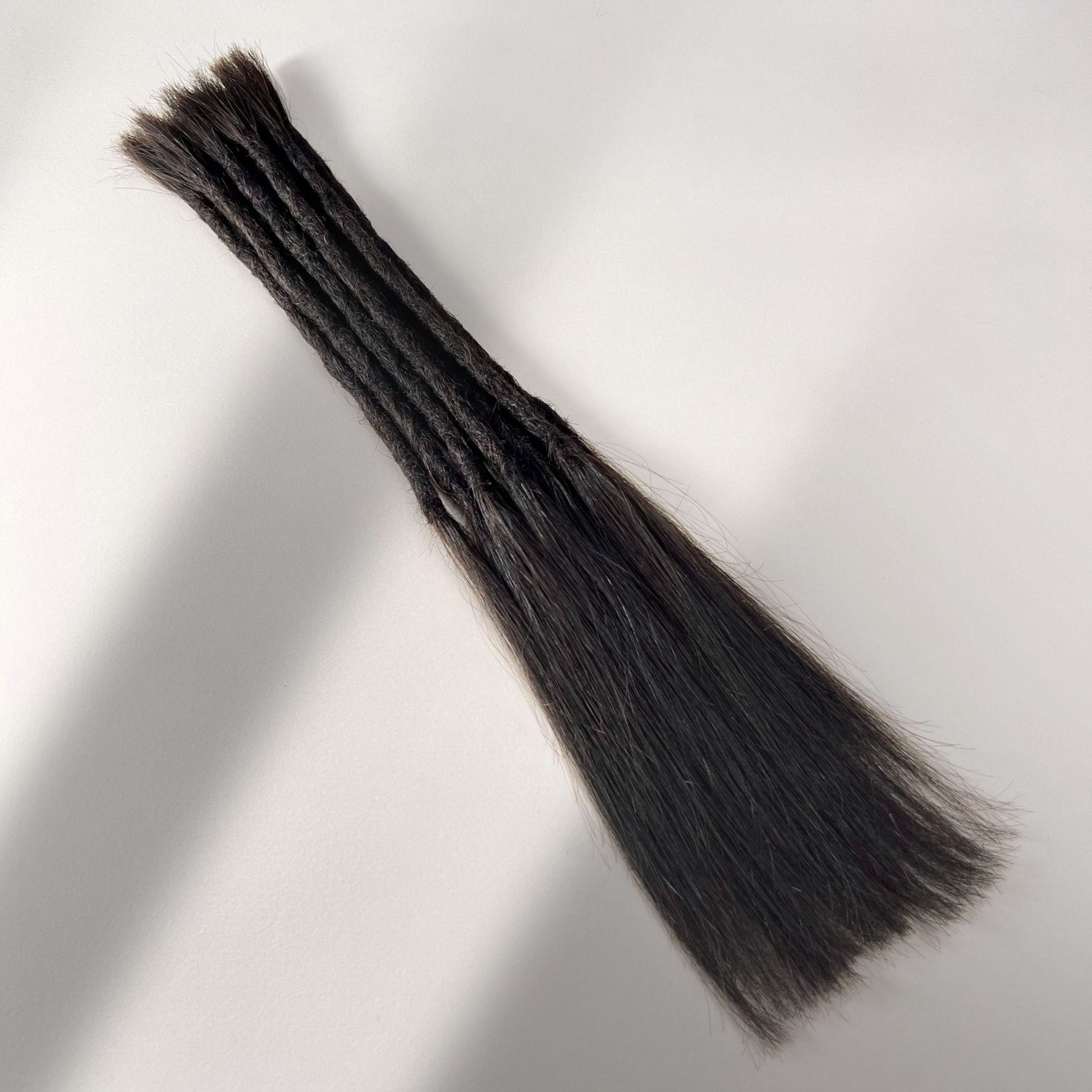 Full view of permanent straight loc extensions with long loose ends in Deep Brown.