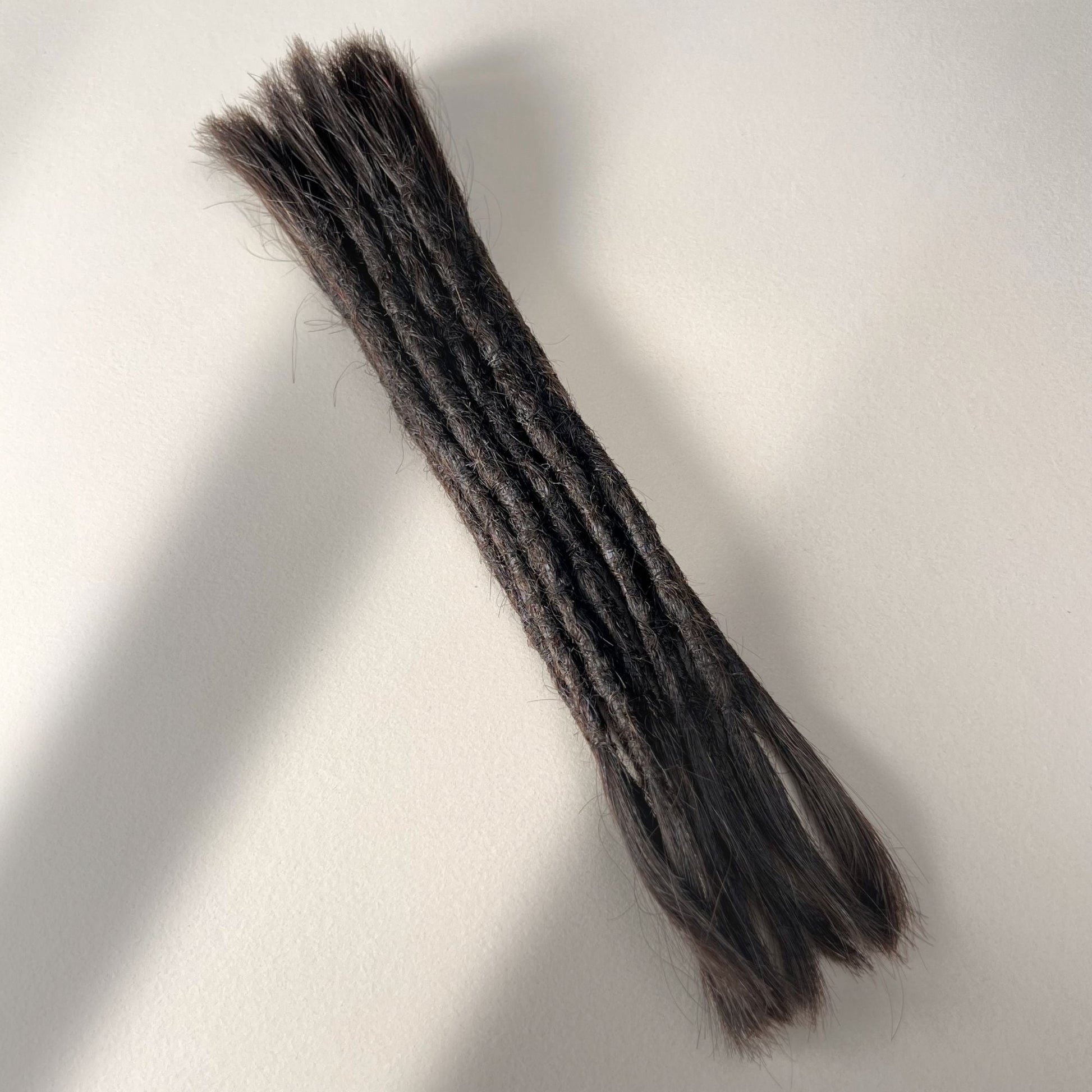 Full view of permanent straight loc extensions with open ends in Deep Brown.