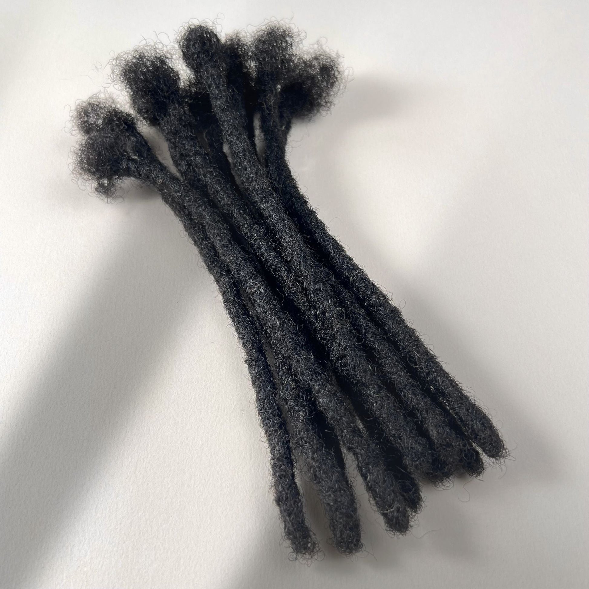 Dark Brown kinky human hair blunt end loc extensions made using the crochet method.