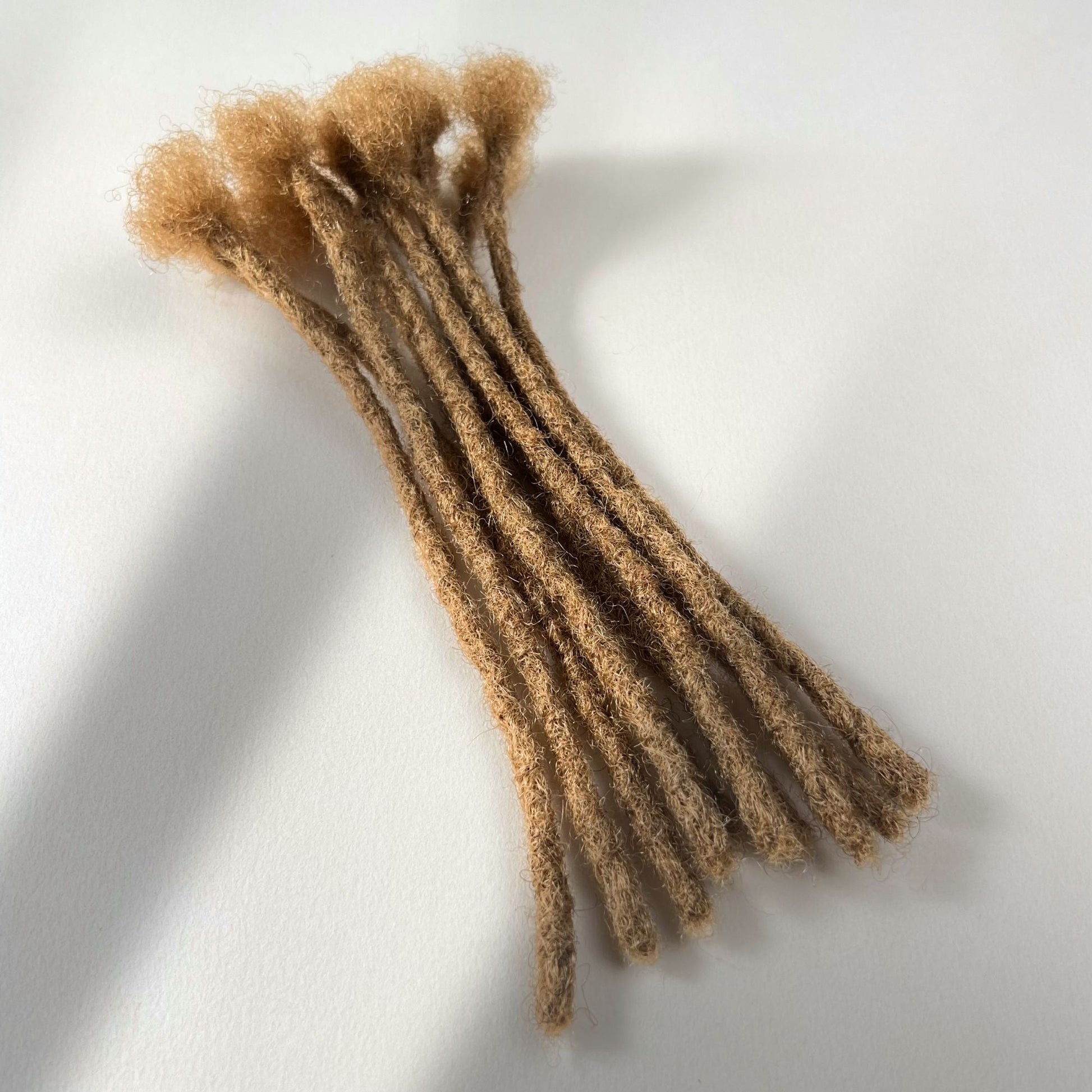 Honey Blonde kinky human hair blunt end loc extensions made using the crochet method.