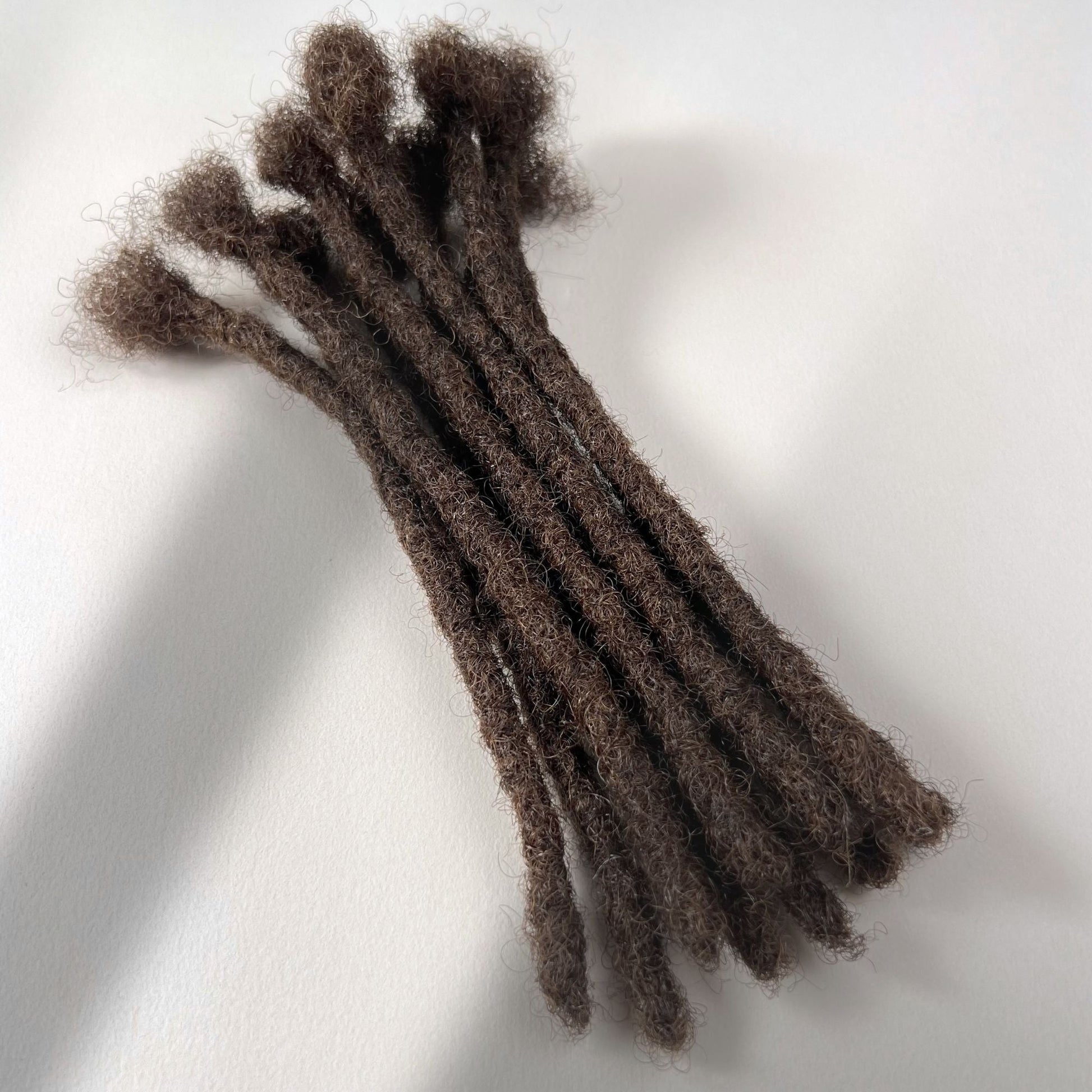 Medium Brown kinky human hair blunt end loc extensions made using the crochet method.