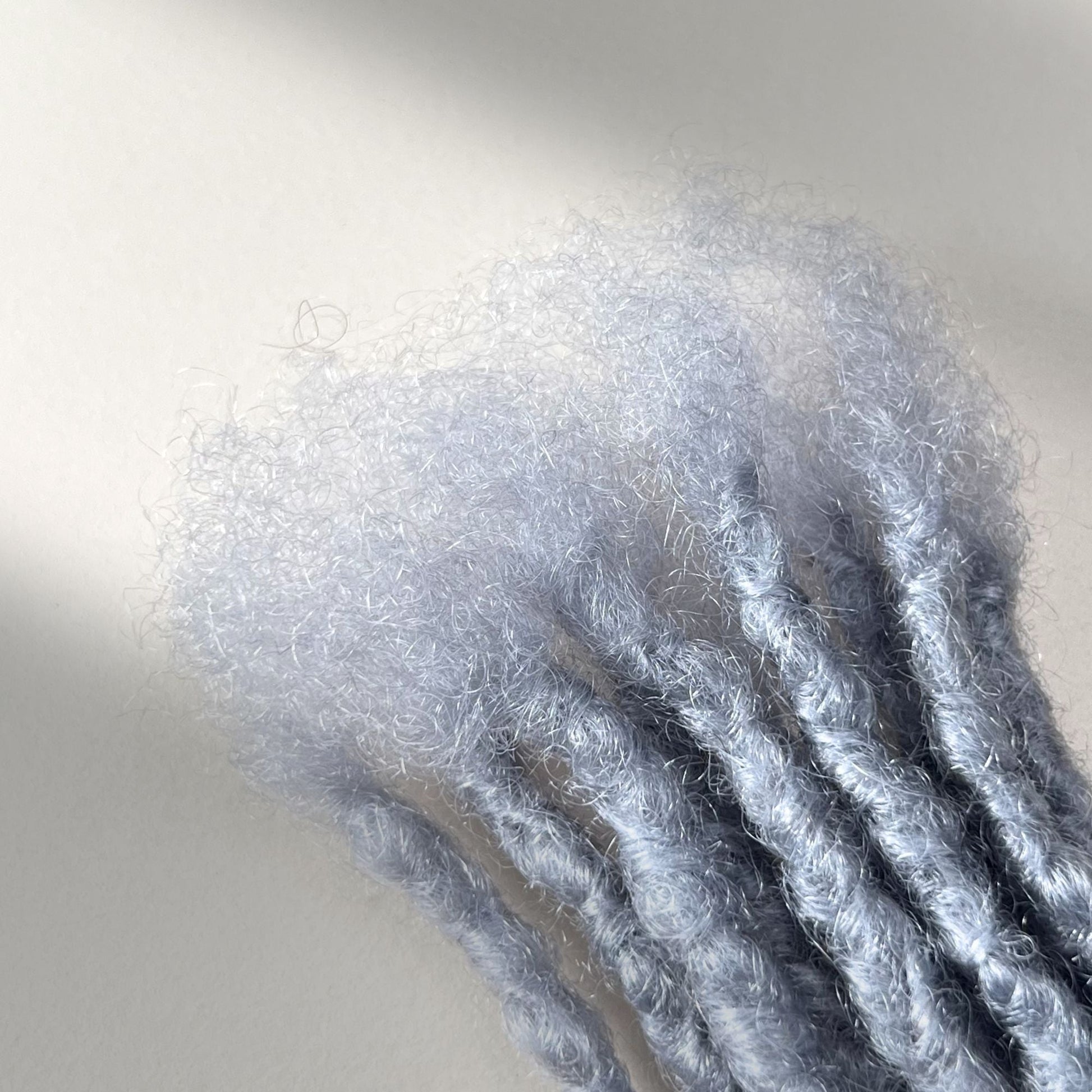 Close-up of the connection point on Grey kinky human hair loc extensions.