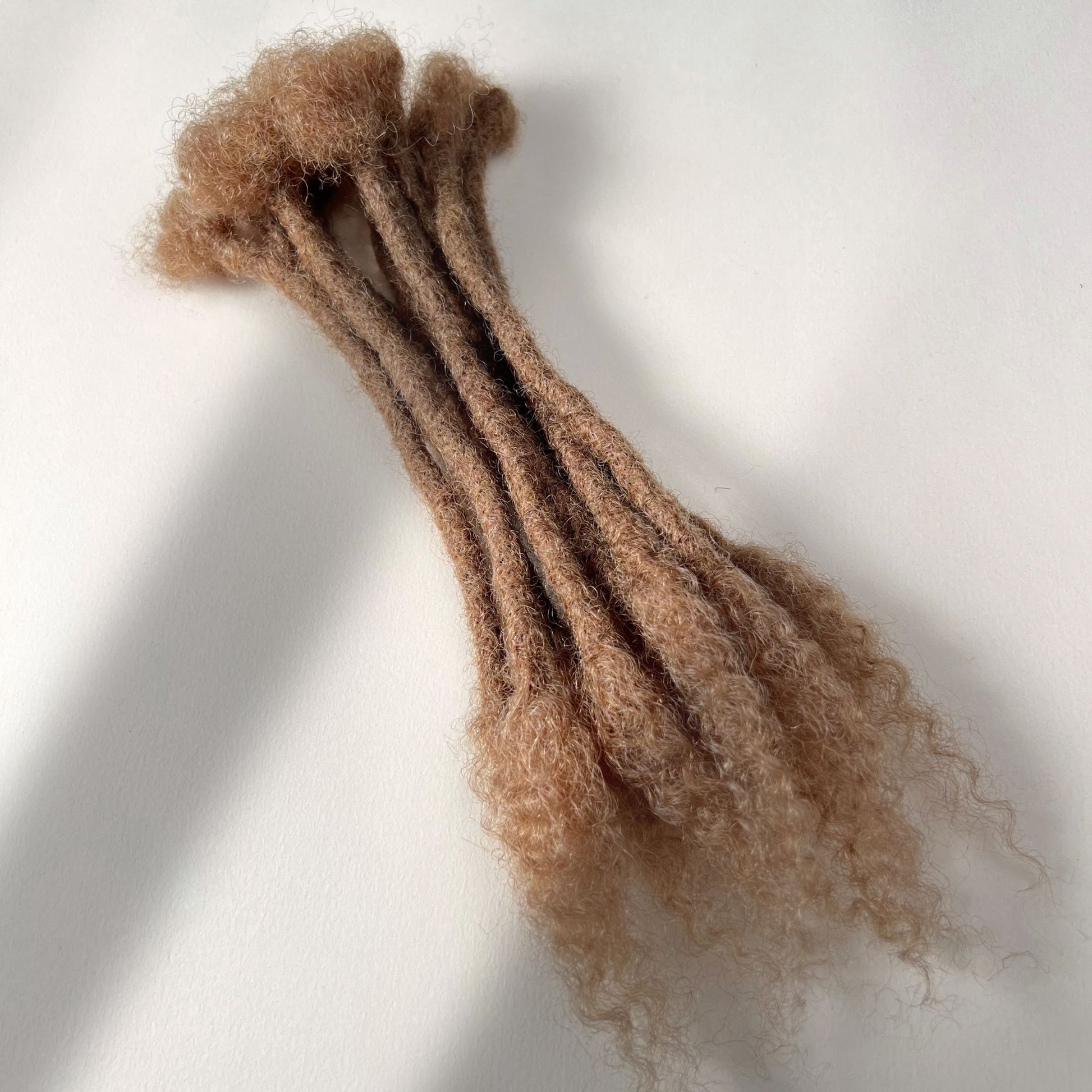 Dark Blonde kinky human hair open end loc extensions made using the crochet method.