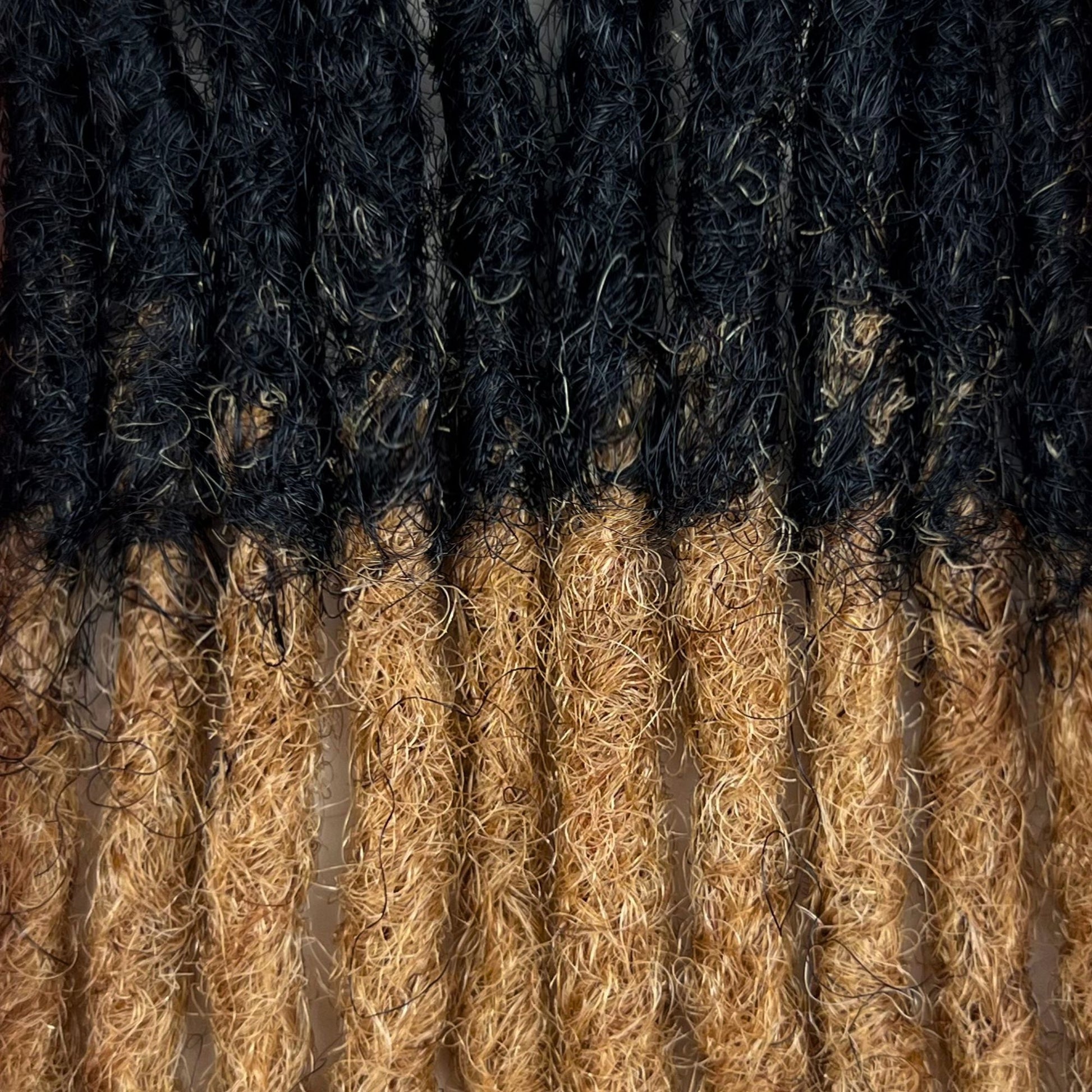 Close-up of Honey Blonde Ombre kinky human hair loc extensions made using the crochet method.