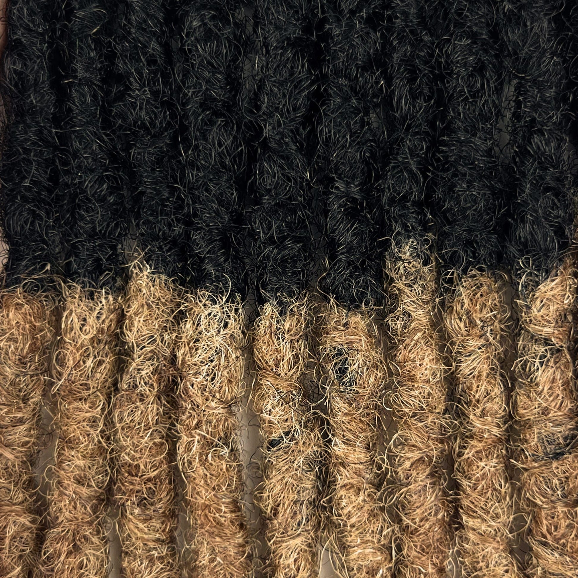 Close-up of Honey Blonde Ombre kinky human hair loc extensions made using the interlocking method.