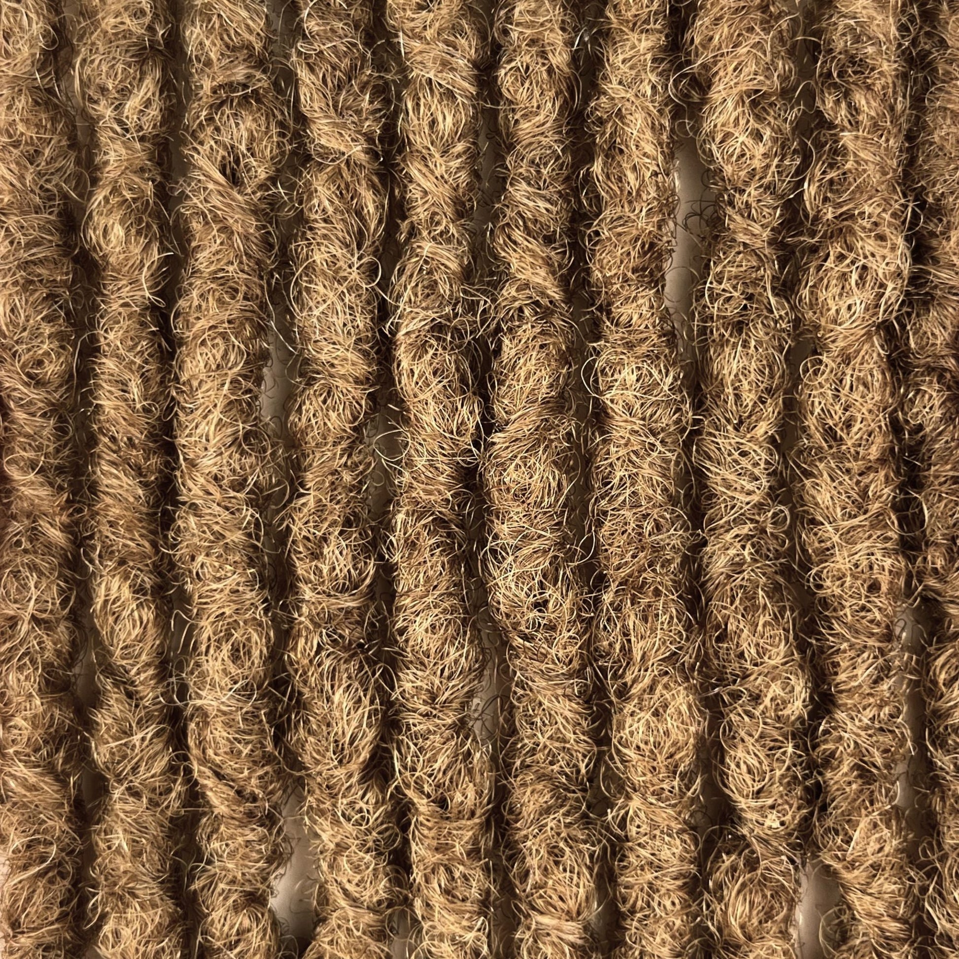 Close-up of Honey Blonde kinky human hair loc extensions made using the interlocking method.
