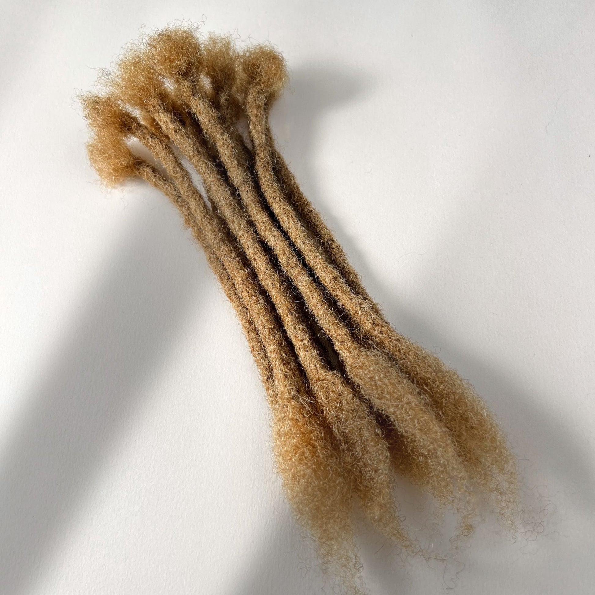 Honey Blonde kinky human hair open end loc extensions made using the crochet method.