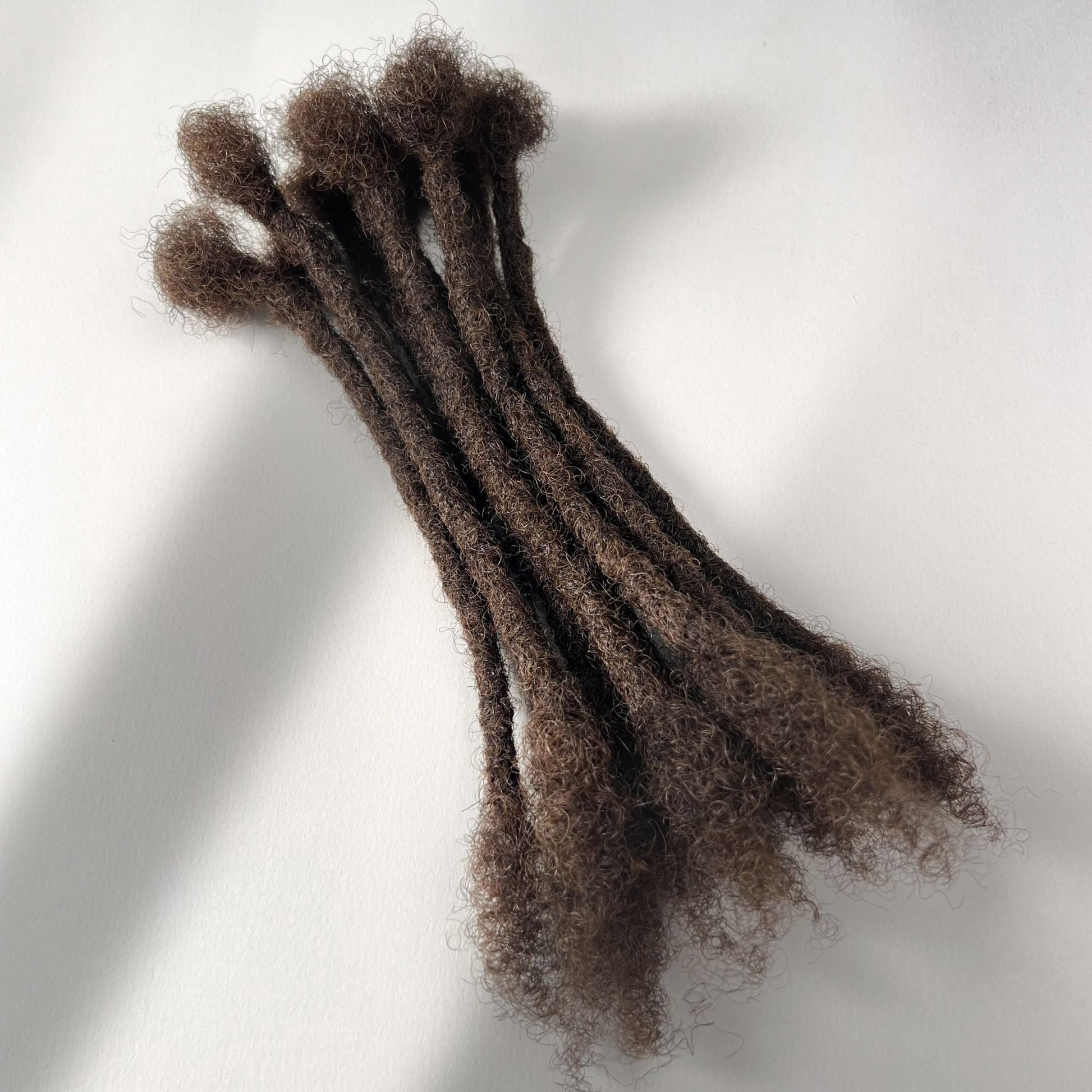 Medium Brown kinky human hair open end loc extensions made using the crochet method.