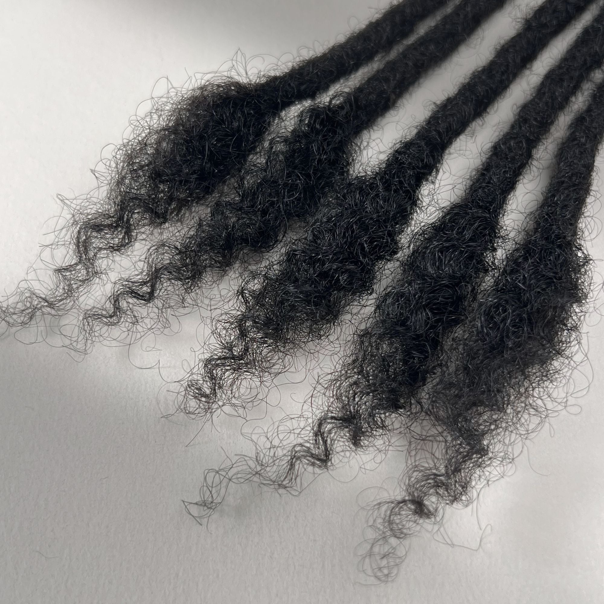 Close-up of the open ends on Dark Brown kinky human hair loc extensions.