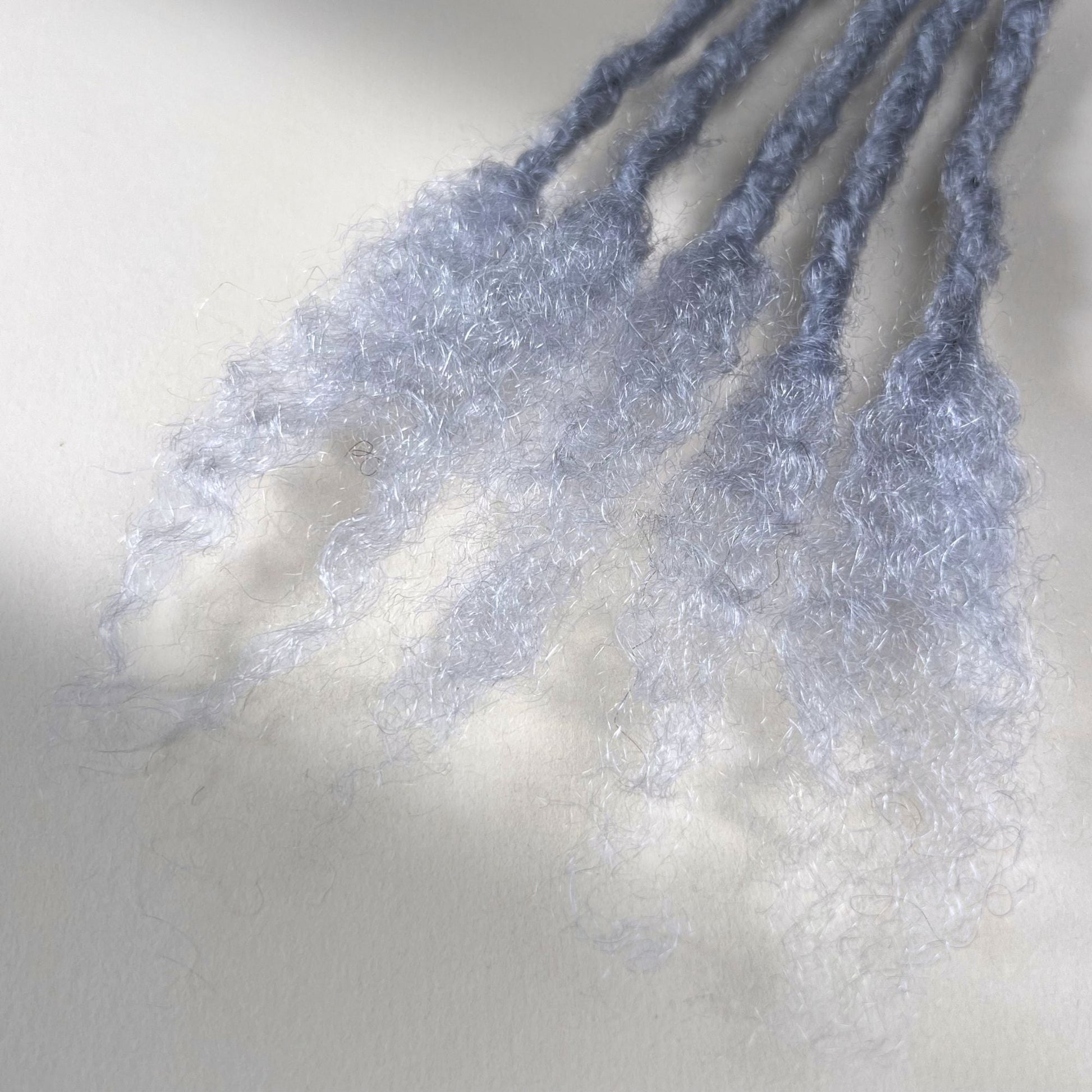 Close-up of the open ends on Grey kinky human hair loc extensions.