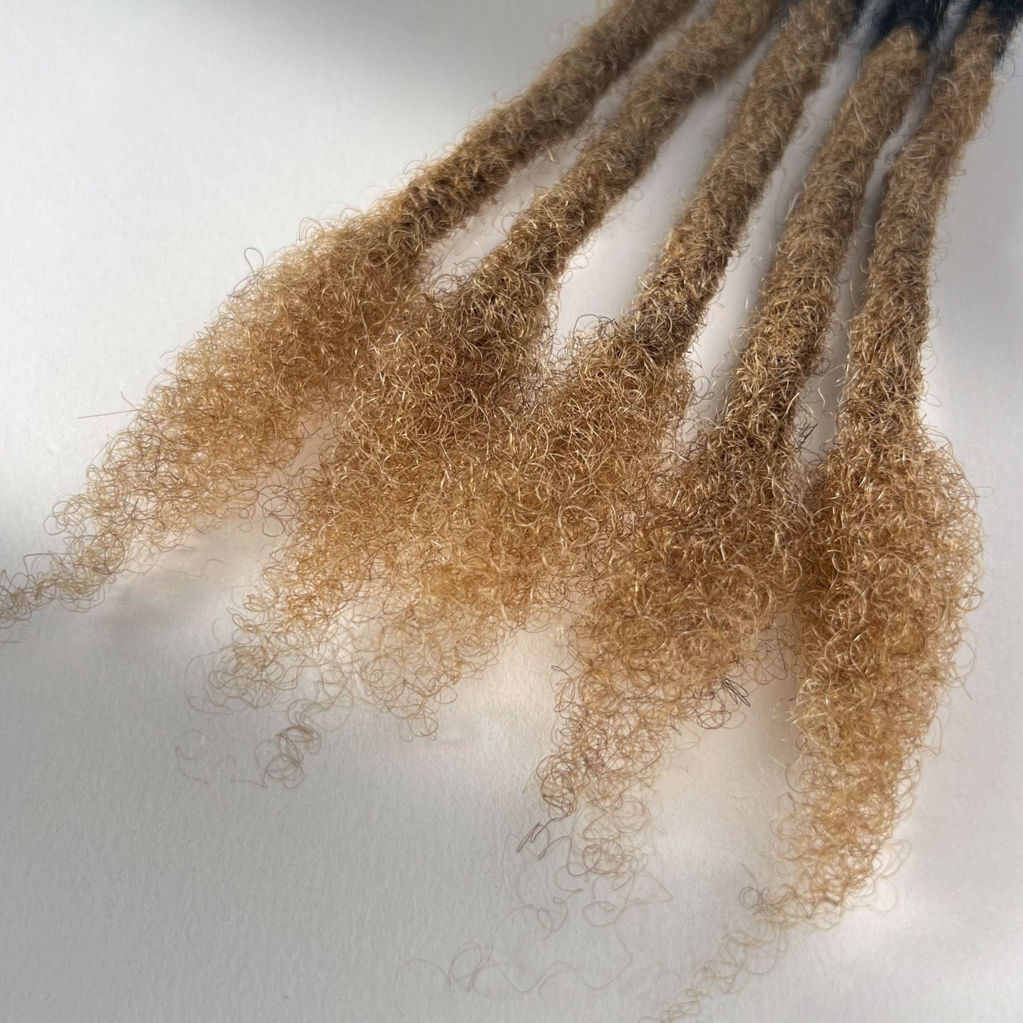 Close-up of the open ends on Honey Blonde Ombre kinky human hair loc extensions.