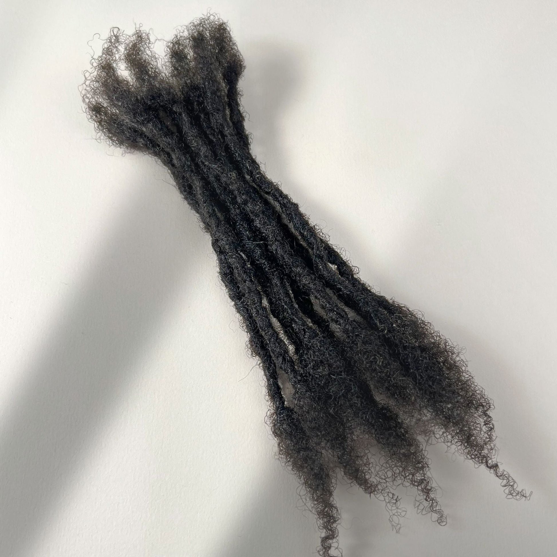 Dark Brown kinky human hair open end loc extensions made using the interlocking method.