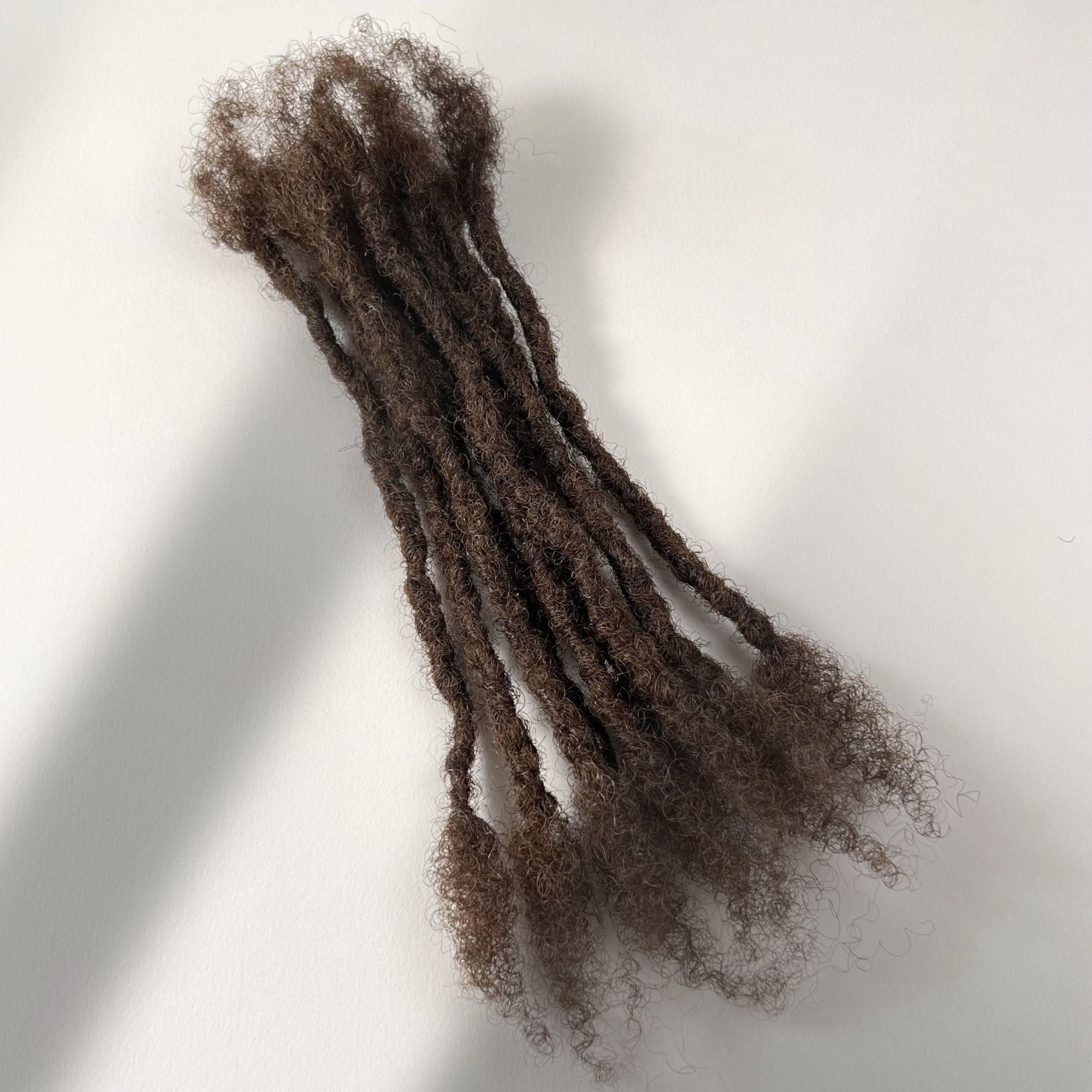 Medium Brown kinky human hair open end loc extensions made using the interlocking method.