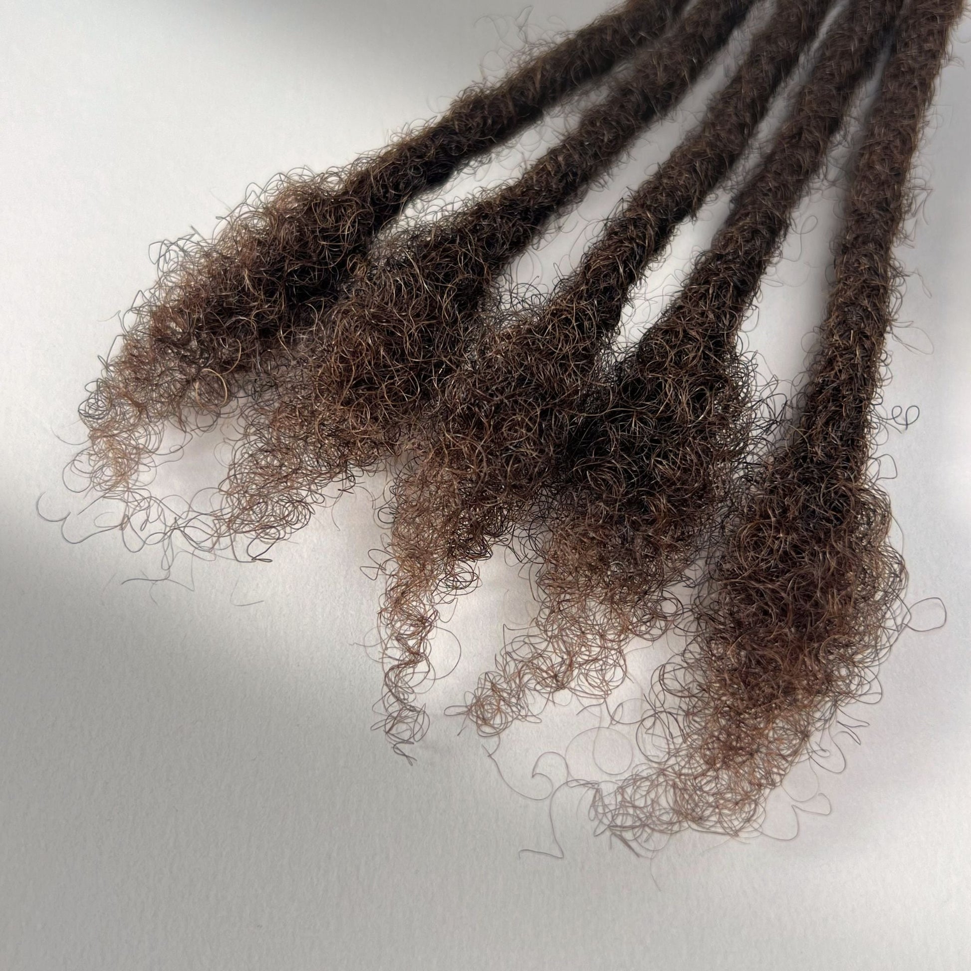 Close-up of the open ends on Medium Brown kinky human hair loc extensions.