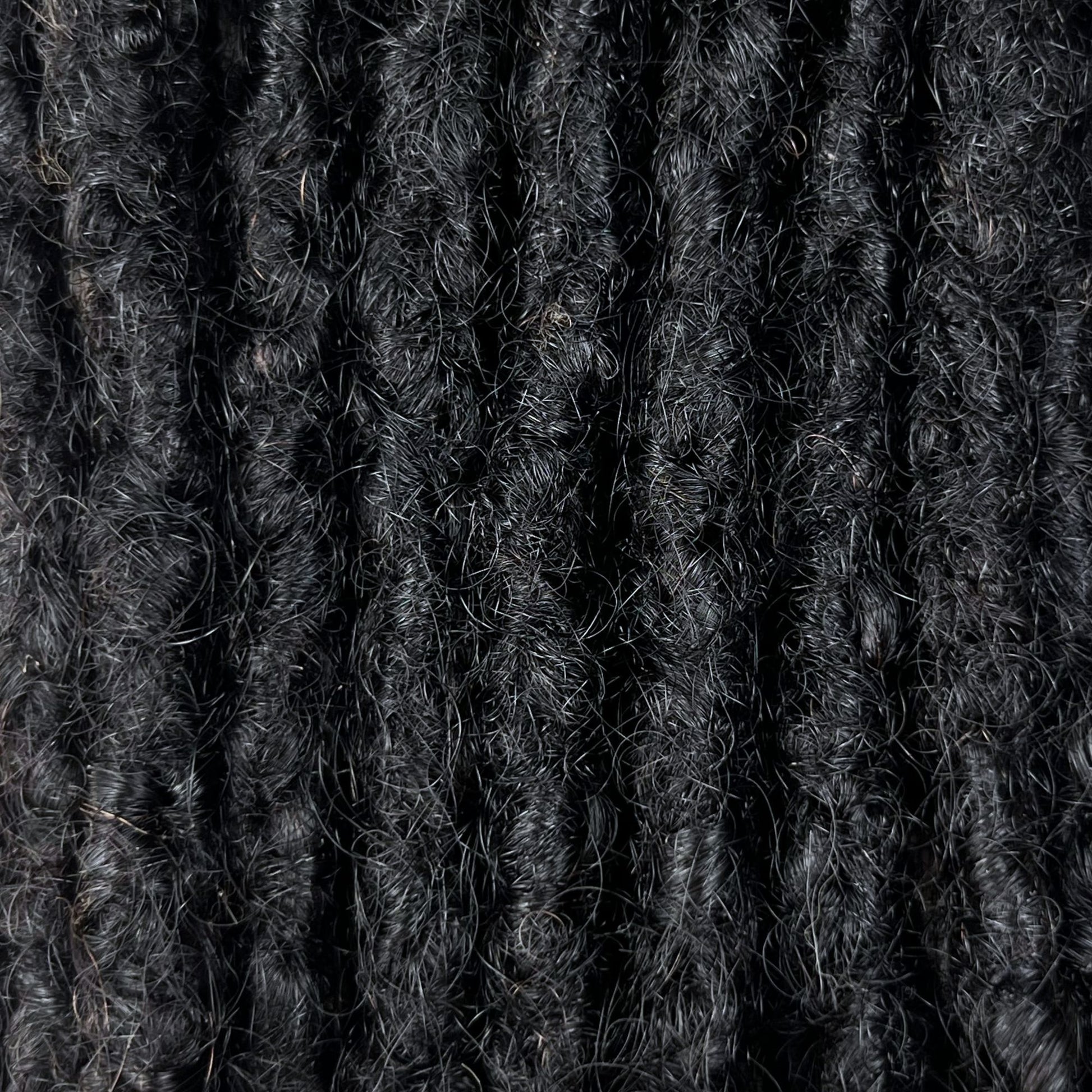 Close-up of Natural Black kinky human hair loc extensions made using the interlocking method.
