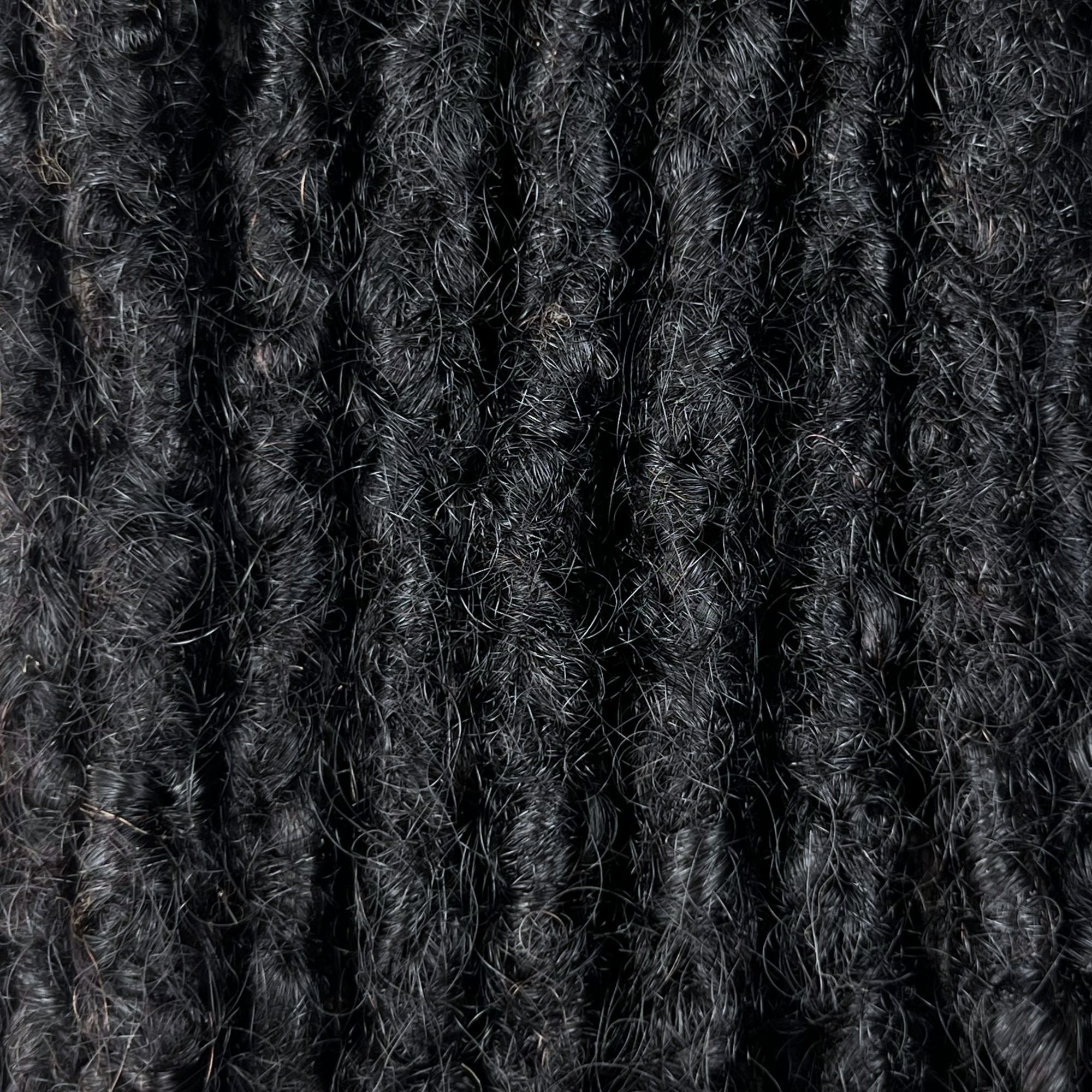 Close-up of Natural Black kinky human hair loc extensions made using the interlocking method.