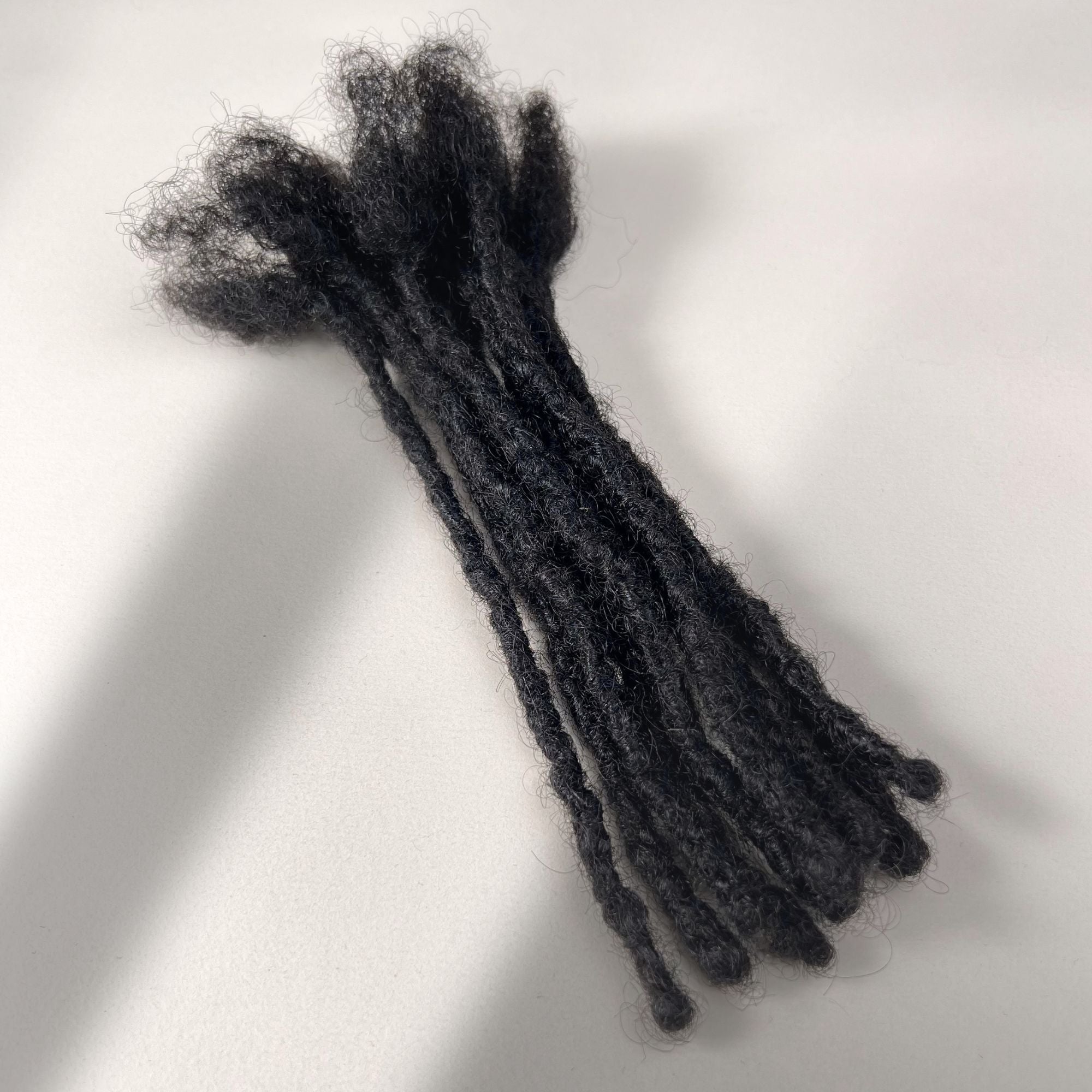 Full view of kinky loc extensions with blunt ends in Natural Black, made using the interlocking method.
