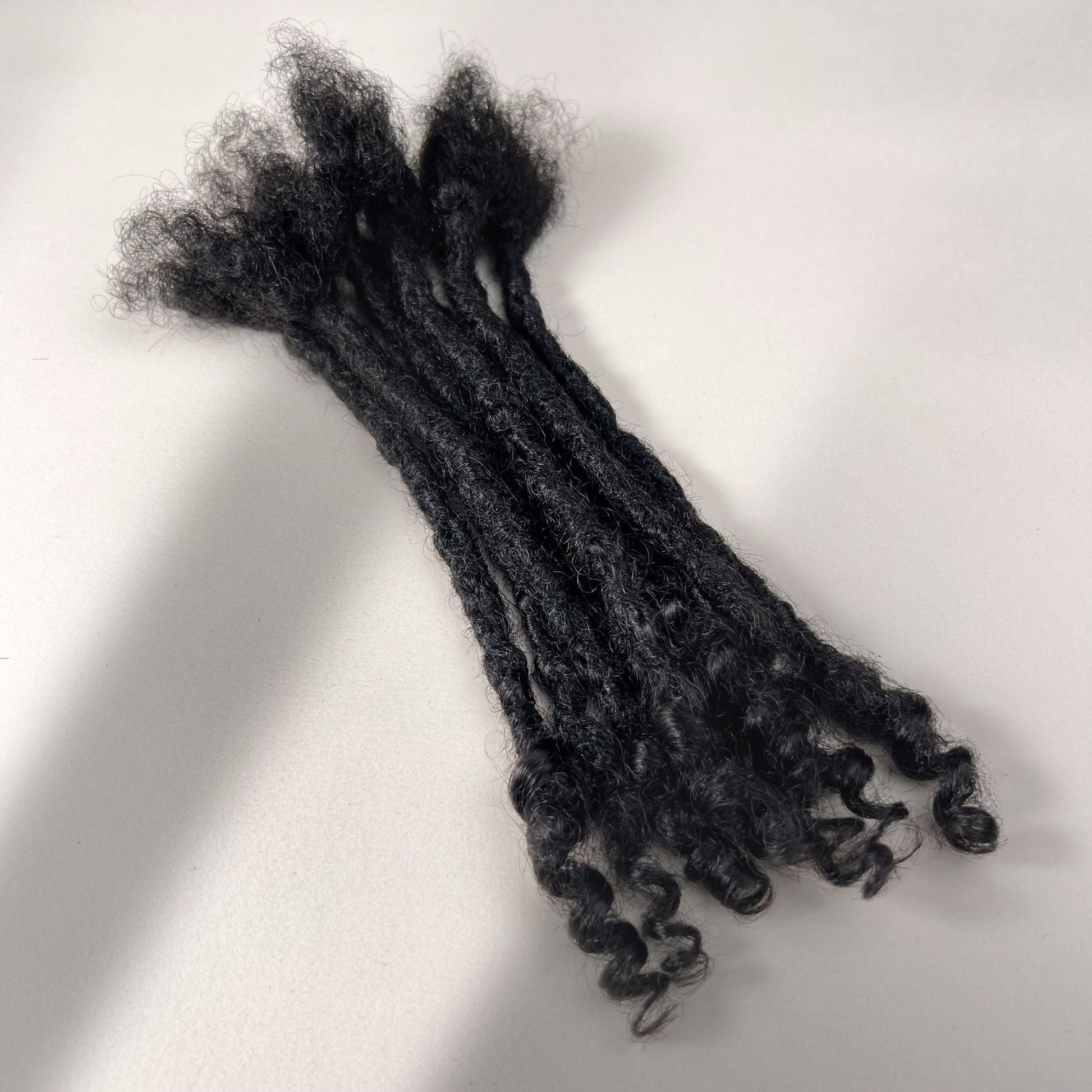 Full view of kinky loc extensions with curly ends in Natural Black, made using the interlocking method.
