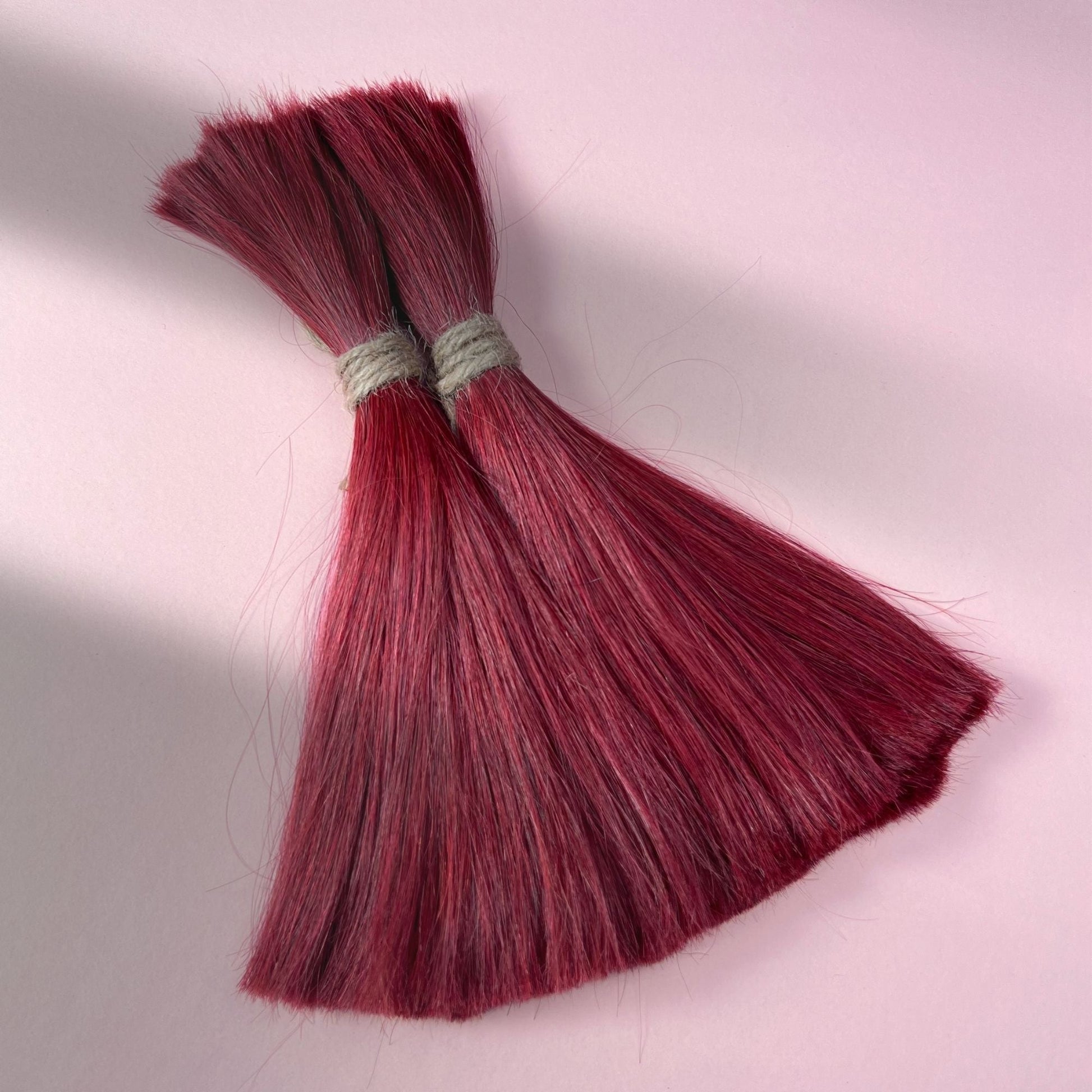Full view of straight human hair in Deep Garnet Red.