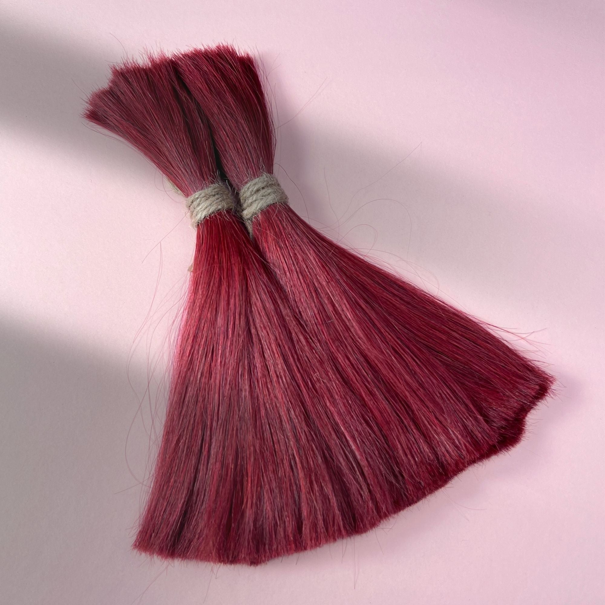 Full view of straight human hair in Deep Garnet Red.