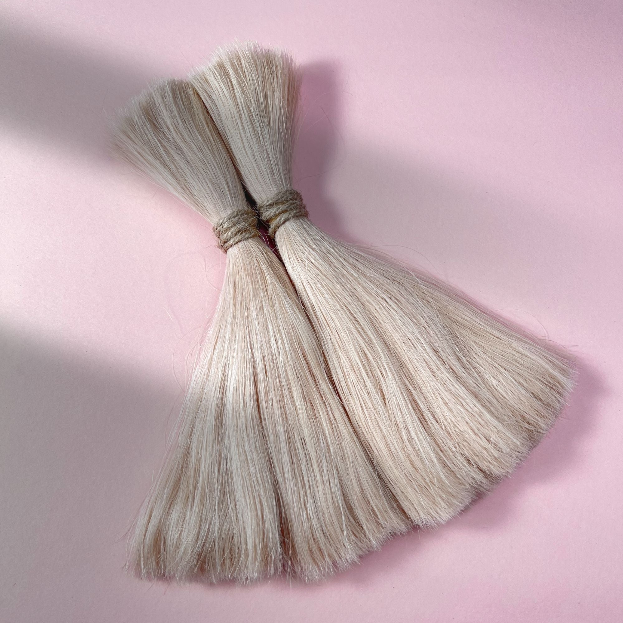Full view of straight human hair in Soft Rose Blonde.