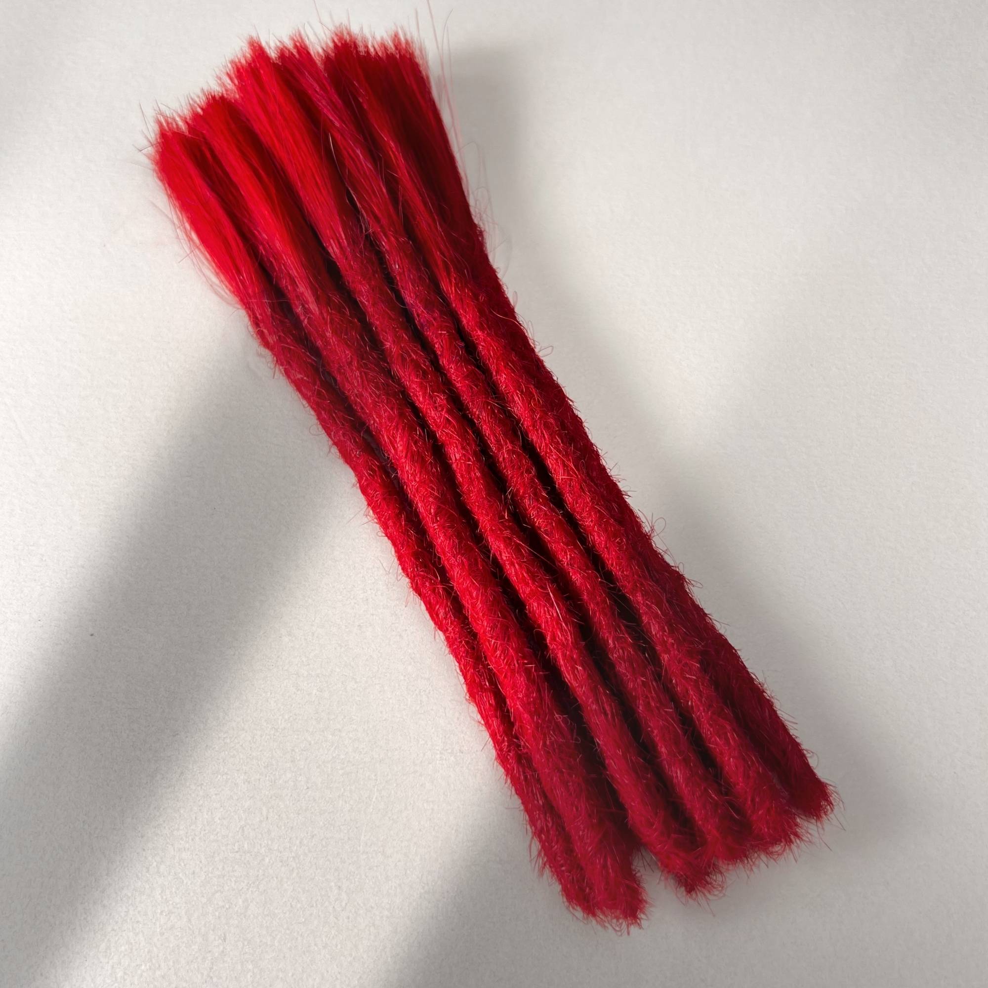 Full view of permanent straight loc extensions with blunt ends in Flame Red. 