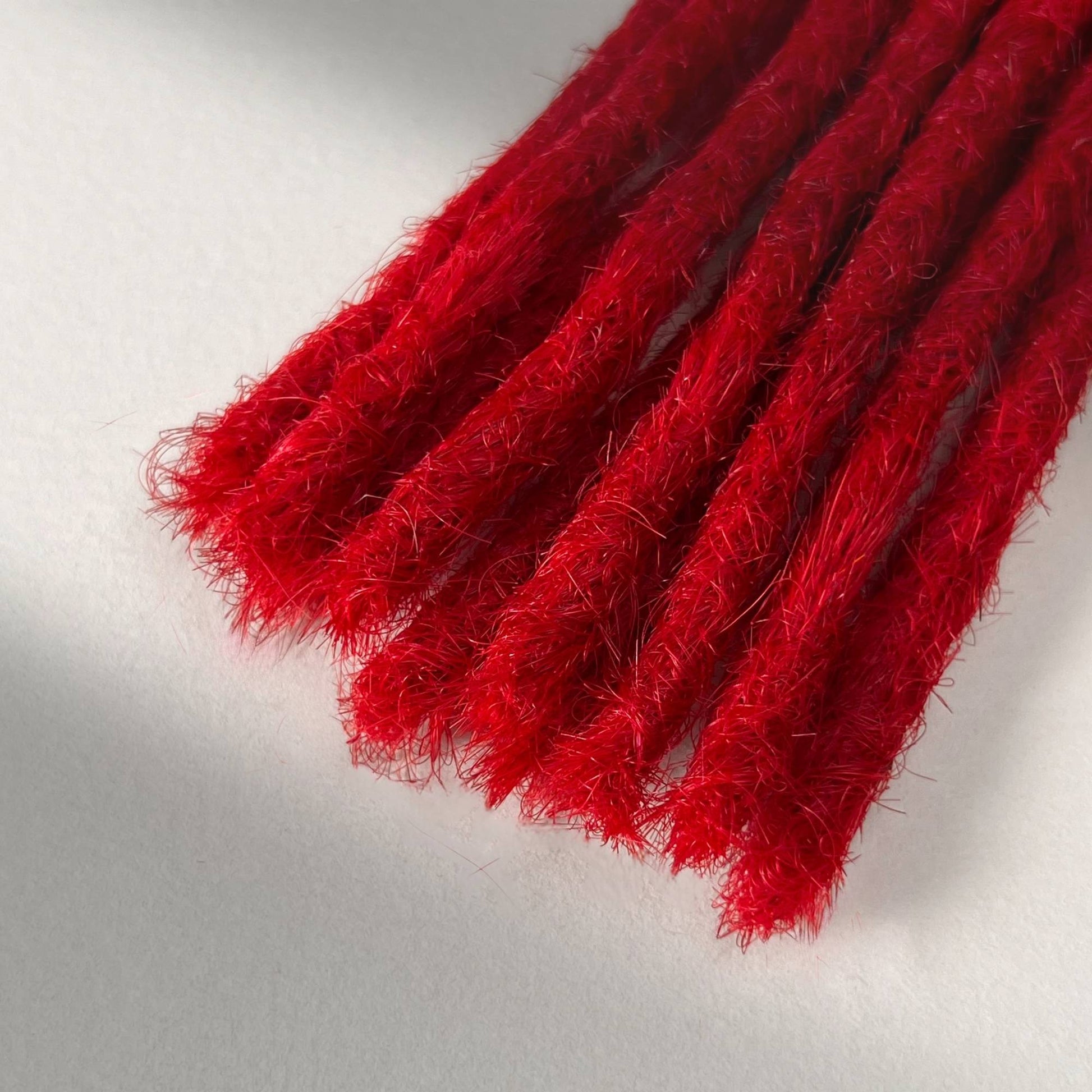Tip detail of straight loc extensions with blunt ends in Flame Red.