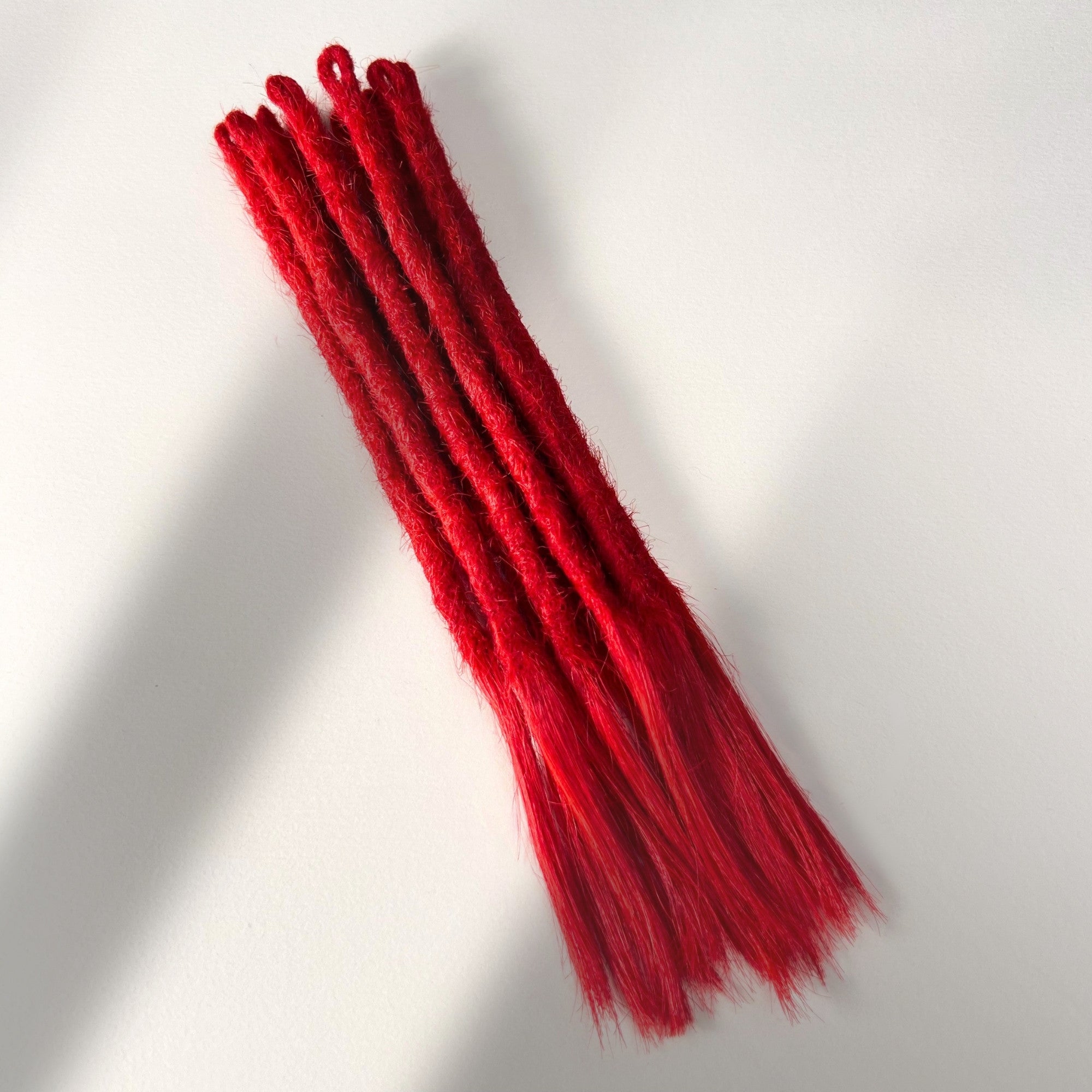 Full view of temporary single-ended straight loc extensions with open ends in Flame Red