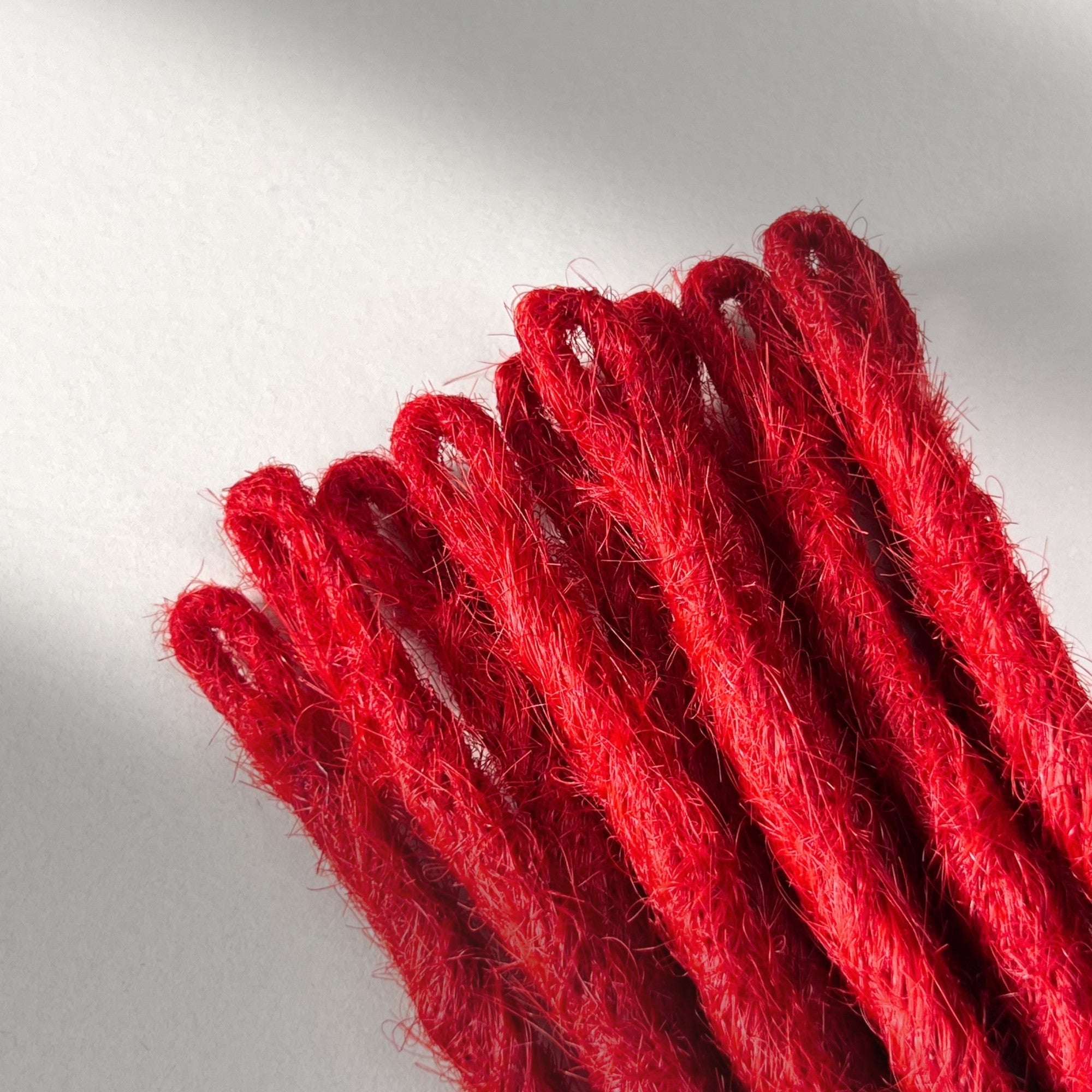Loop detail of temporary single-ended straight loc extensions in Flame Red.