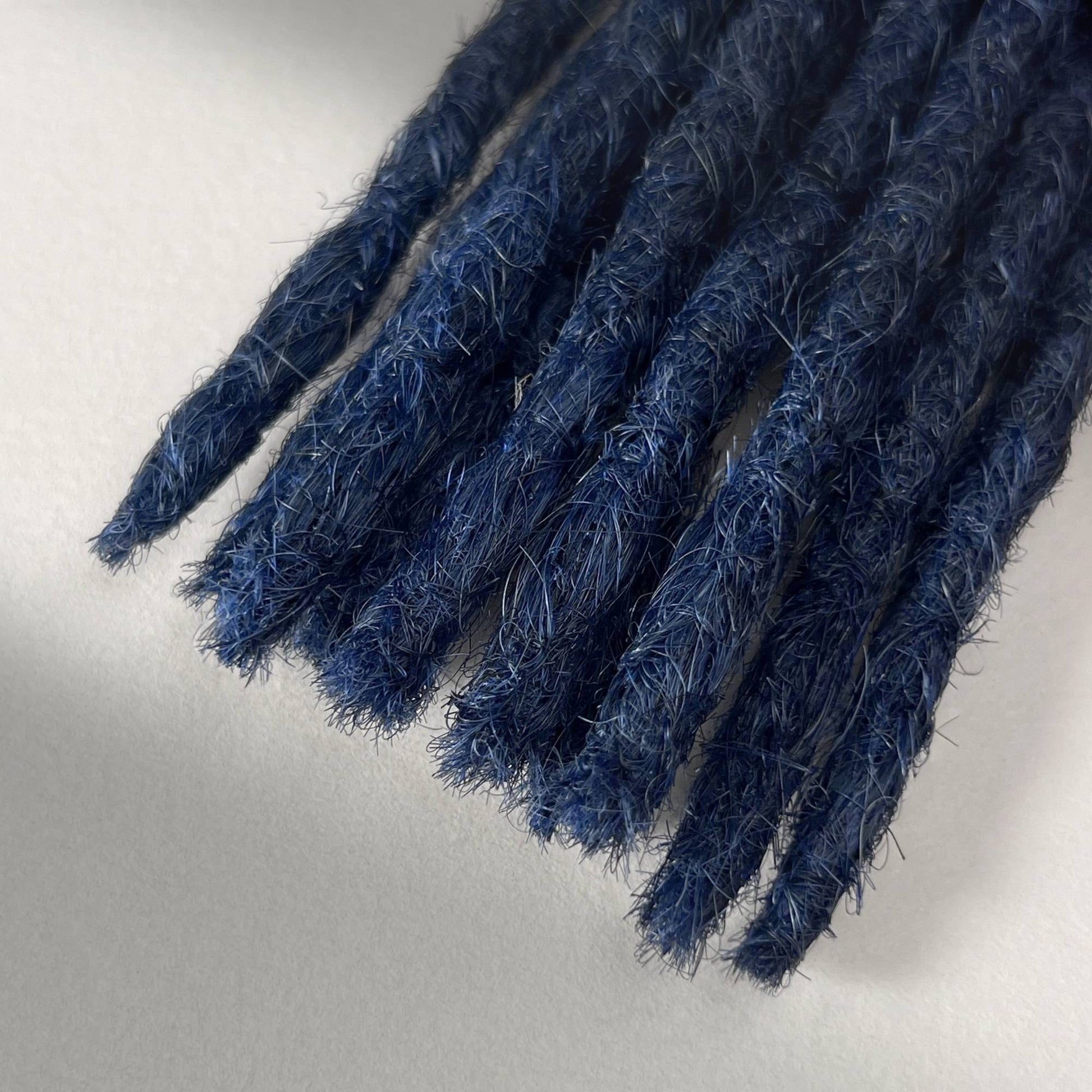 Tip detail of straight loc extensions with blunt ends in Midnight Blue.