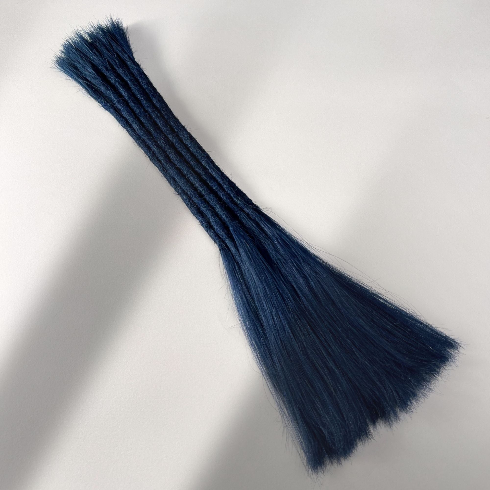 Full view of permanent straight loc extensions with long loose ends in Midnight Blue.