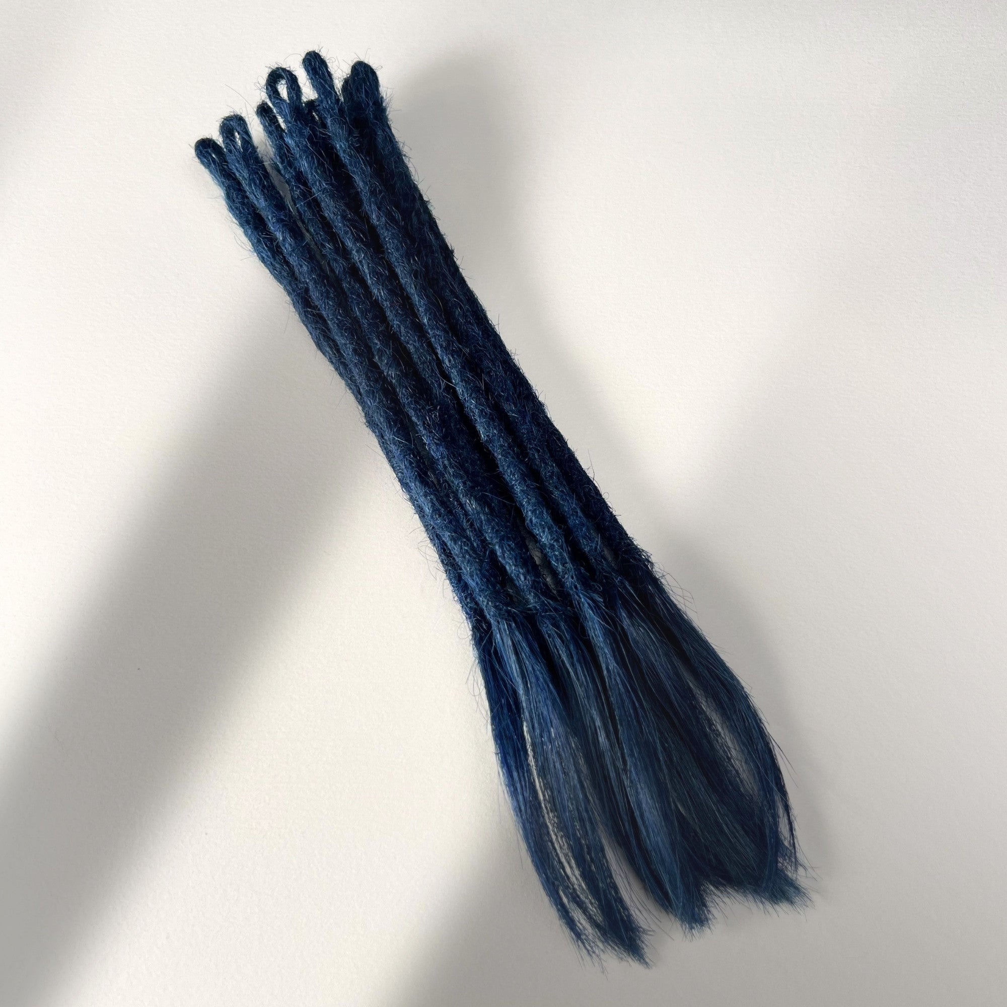 Full view of temporary single-ended straight loc extensions with open ends in Midnight Blue.
