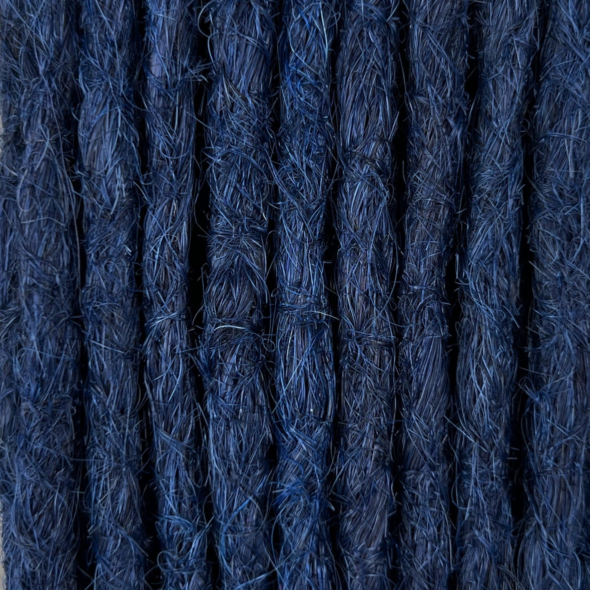 Close-up of straight loc extensions in Midnight Blue, showing the texture and color.