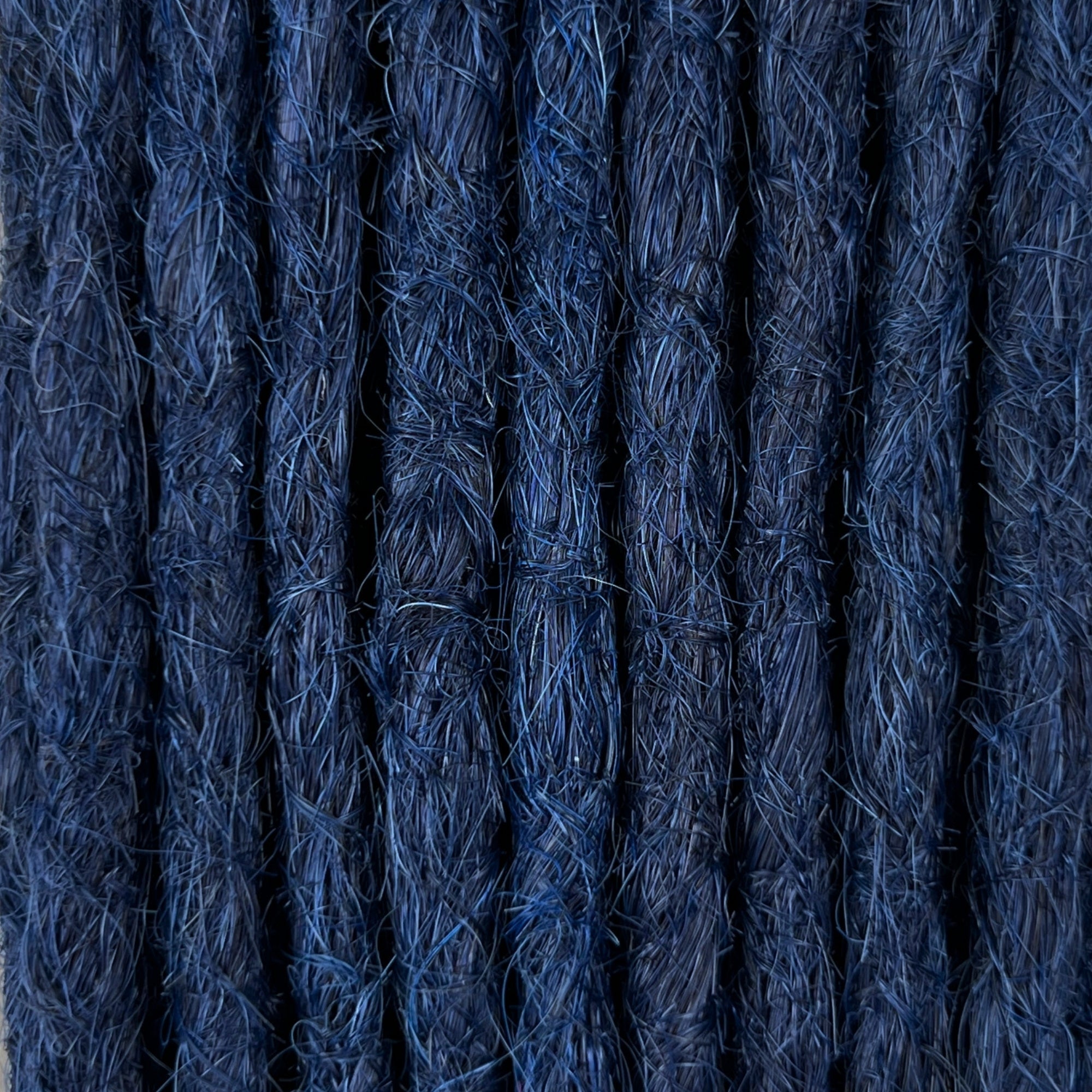 Close-up of straight loc extensions in Midnight Blue, showing the texture and color.