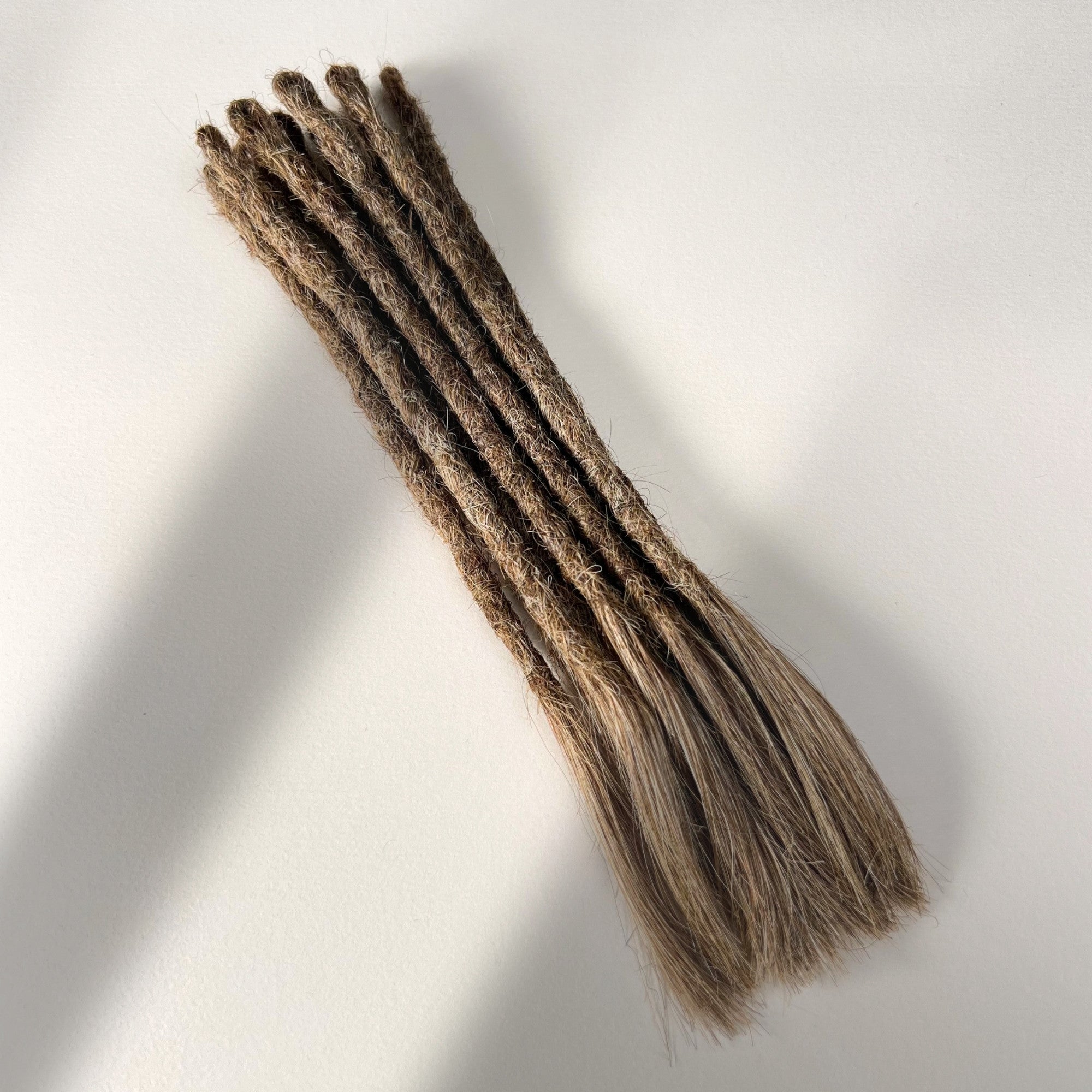 Full view of temporary single-ended straight loc extensions with open ends in Light Beige Blonde.