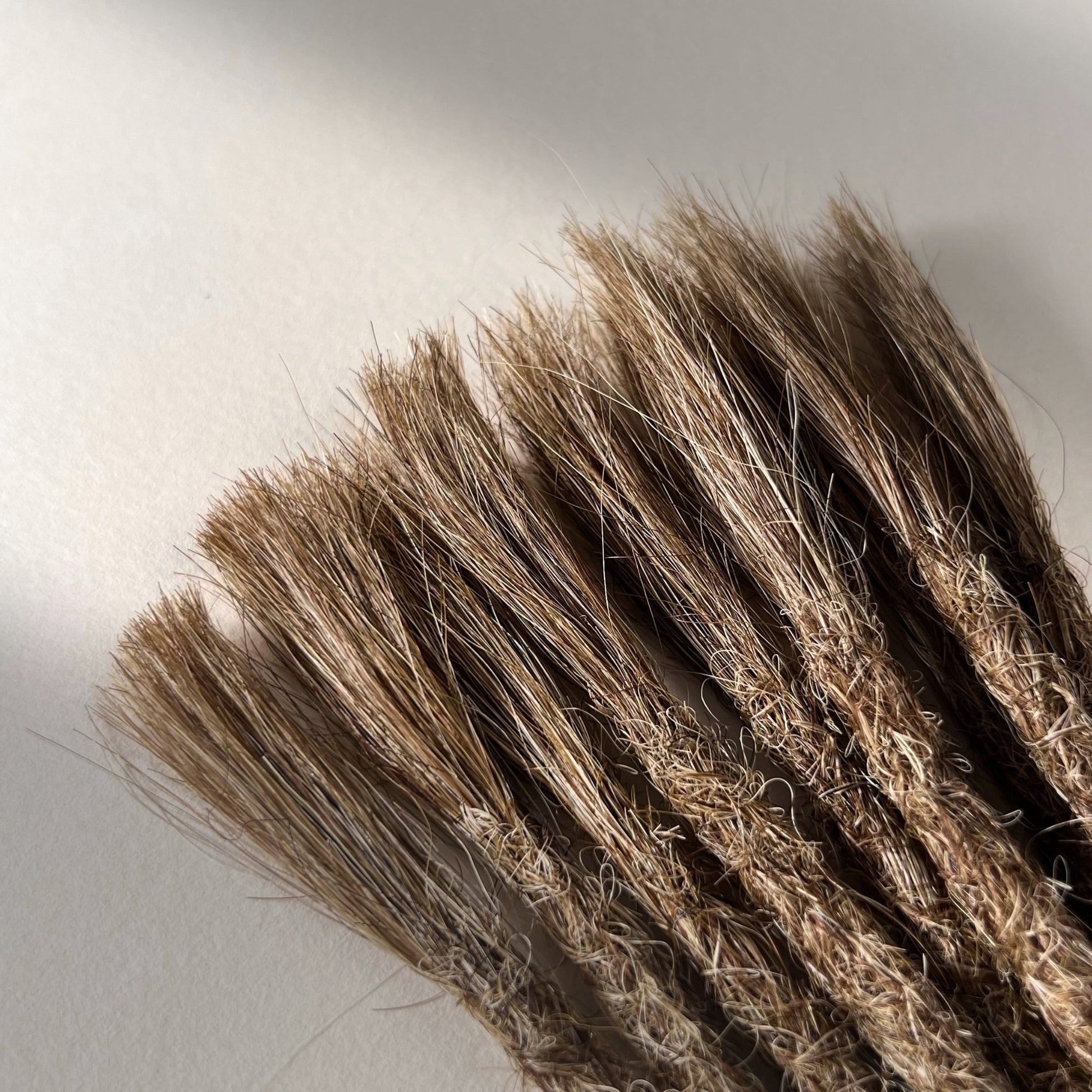 Connection point of permanent straight loc extensions in Light Beige Blonde.