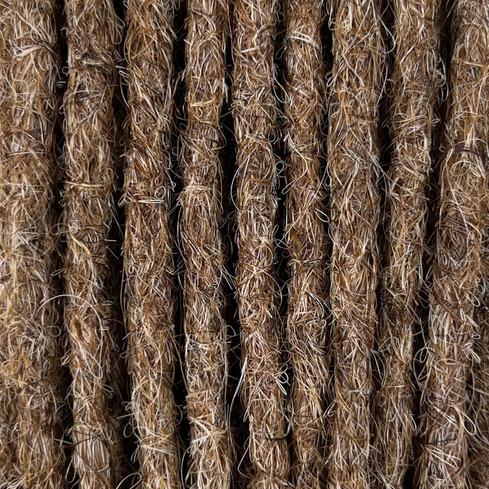 Close-up of straight loc extensions in Light Beige Blonde, showing the texture and color.
