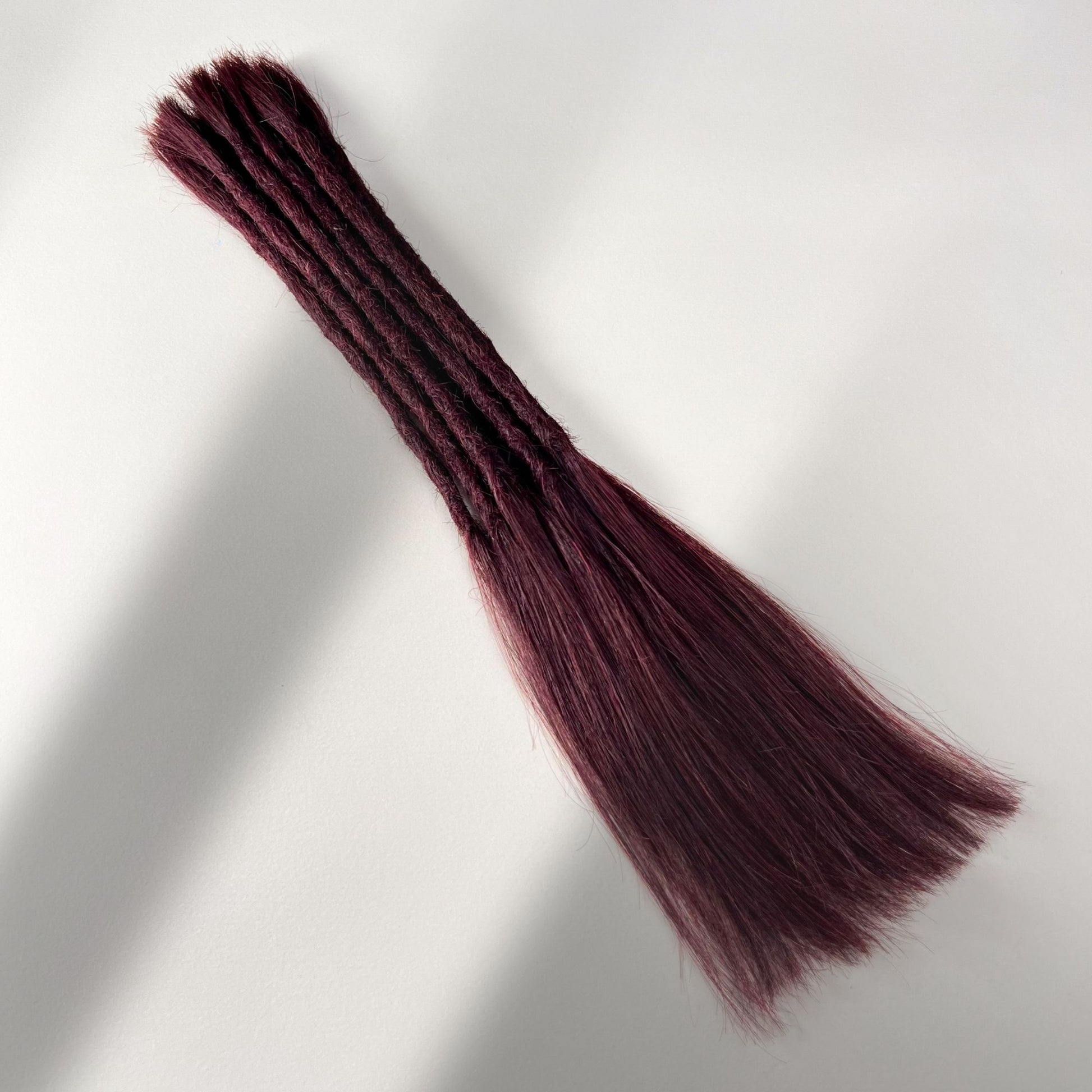 Full view of permanent straight loc extensions with long loose ends in Rich Burgundy Red.