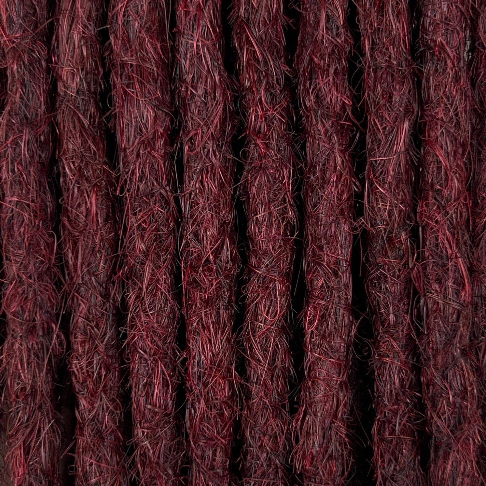 Close-up of straight loc extensions in Rich Burgundy Red, showing the texture and color.