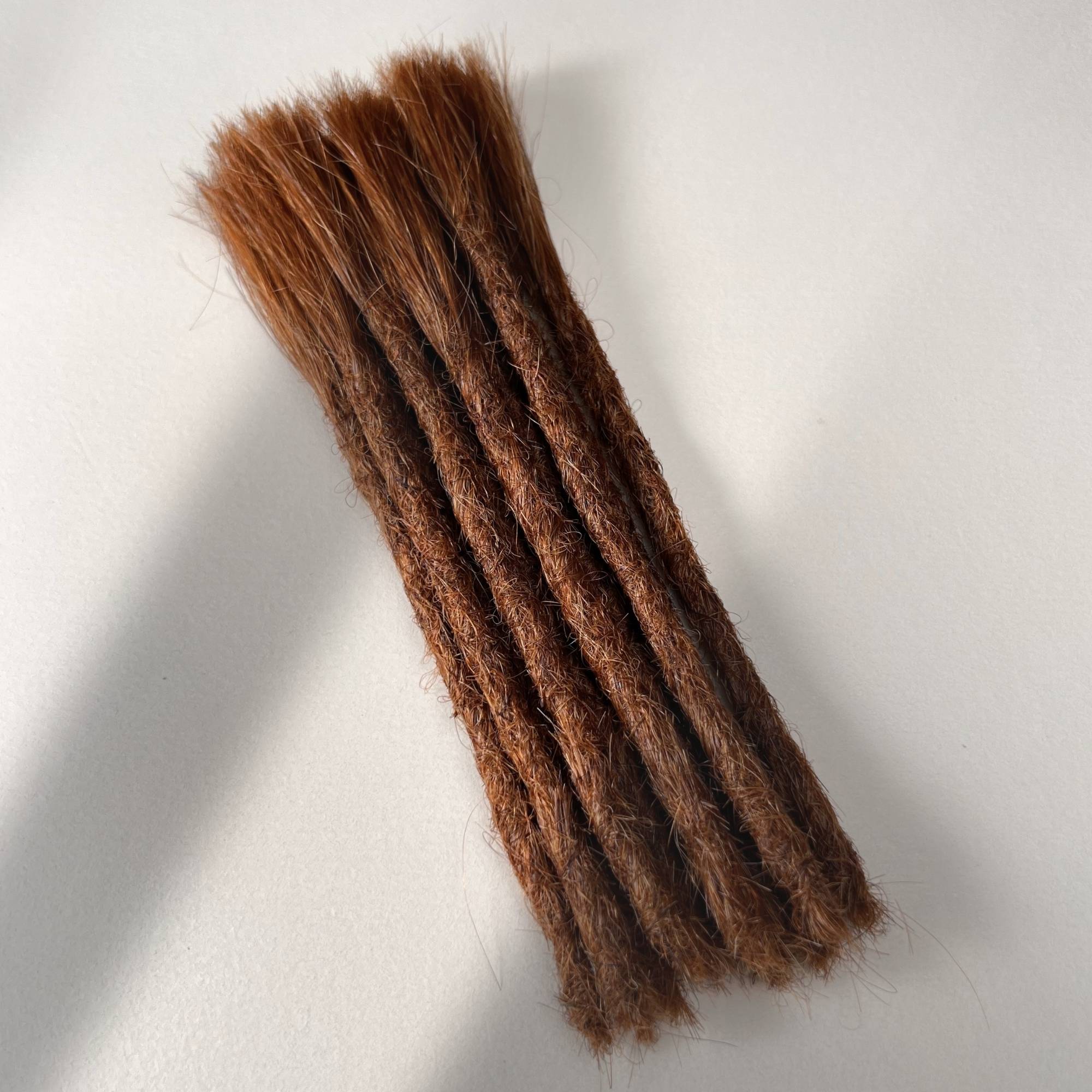 Full view of permanent straight loc extensions with blunt ends in Burnt Sienna Copper.