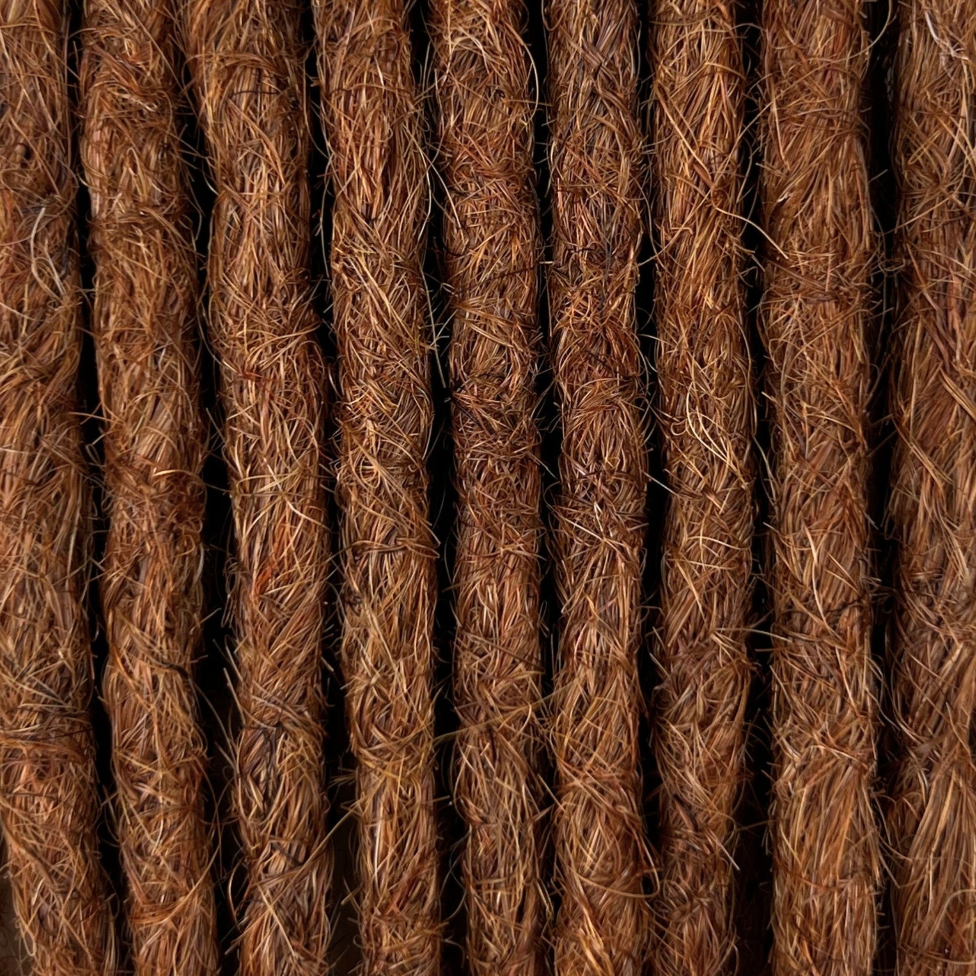 Close-up of straight loc extensions in Burnt Sienna Copper, showing the texture and color.