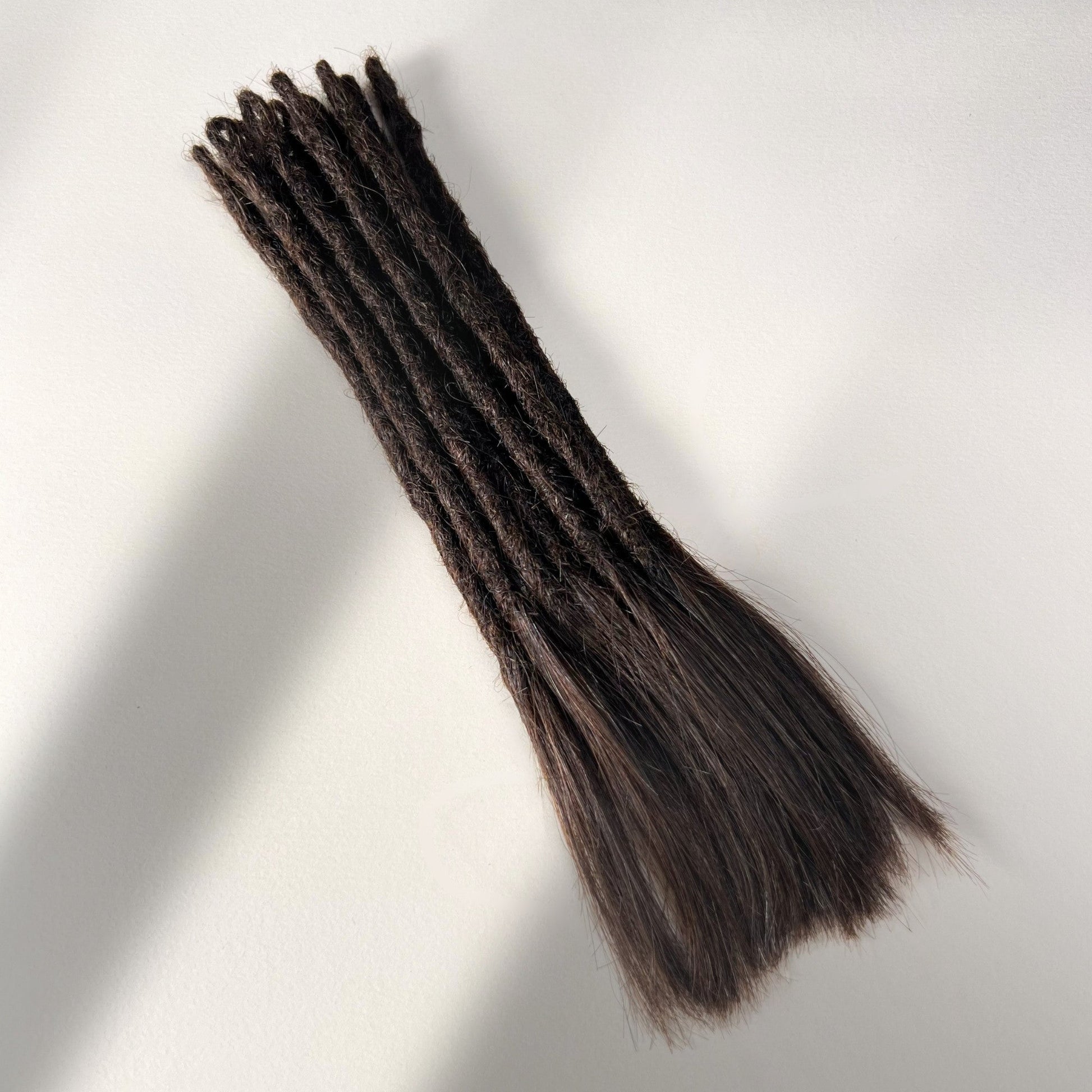 Full view of temporary single-ended straight loc extensions with open ends in Warm Caramel Brown.